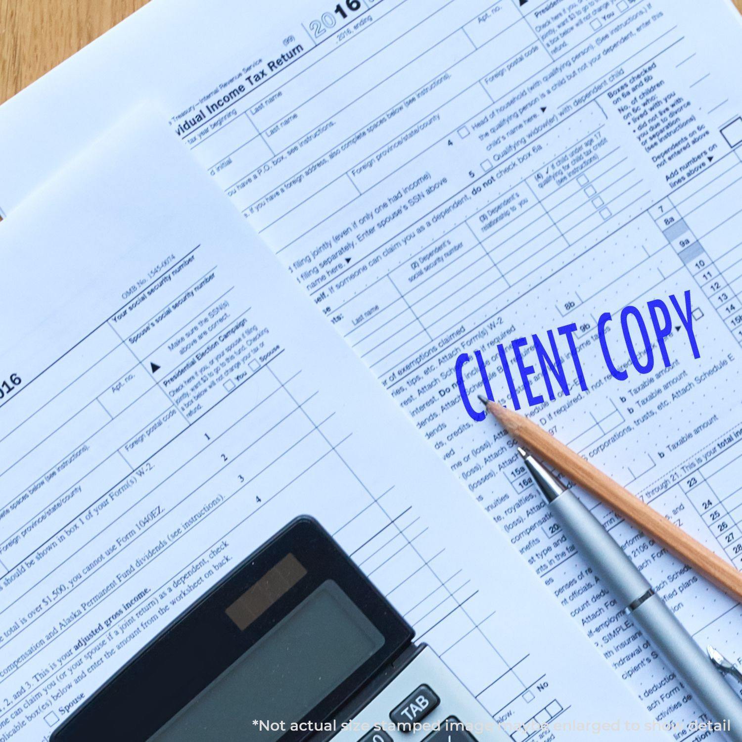 Large Self Inking Client Copy Stamp marking a tax document with CLIENT COPY in blue ink, next to a pencil and calculator.