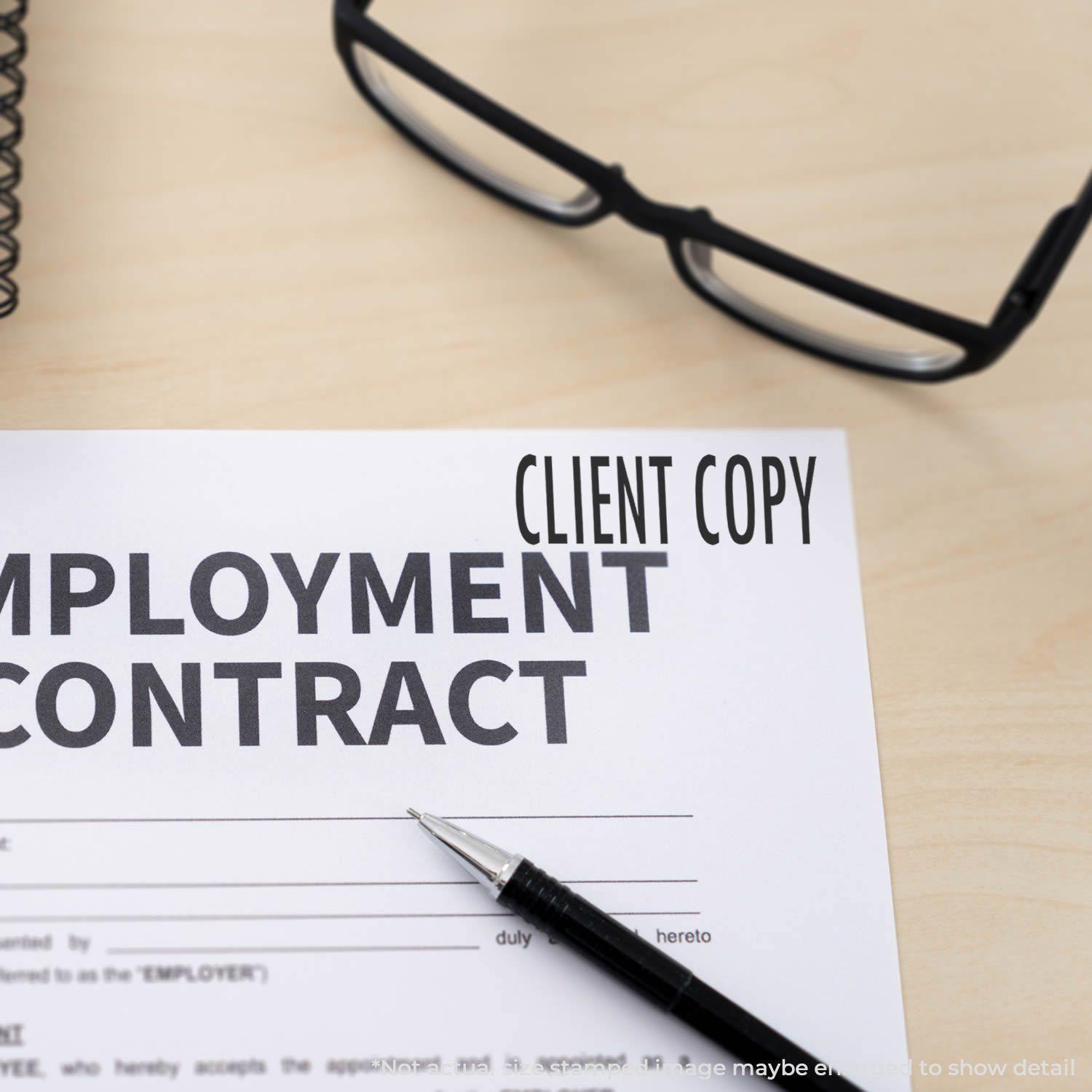 A Self Inking Client Copy Stamp marks CLIENT COPY on an employment contract, with glasses and a pen nearby on a wooden desk.