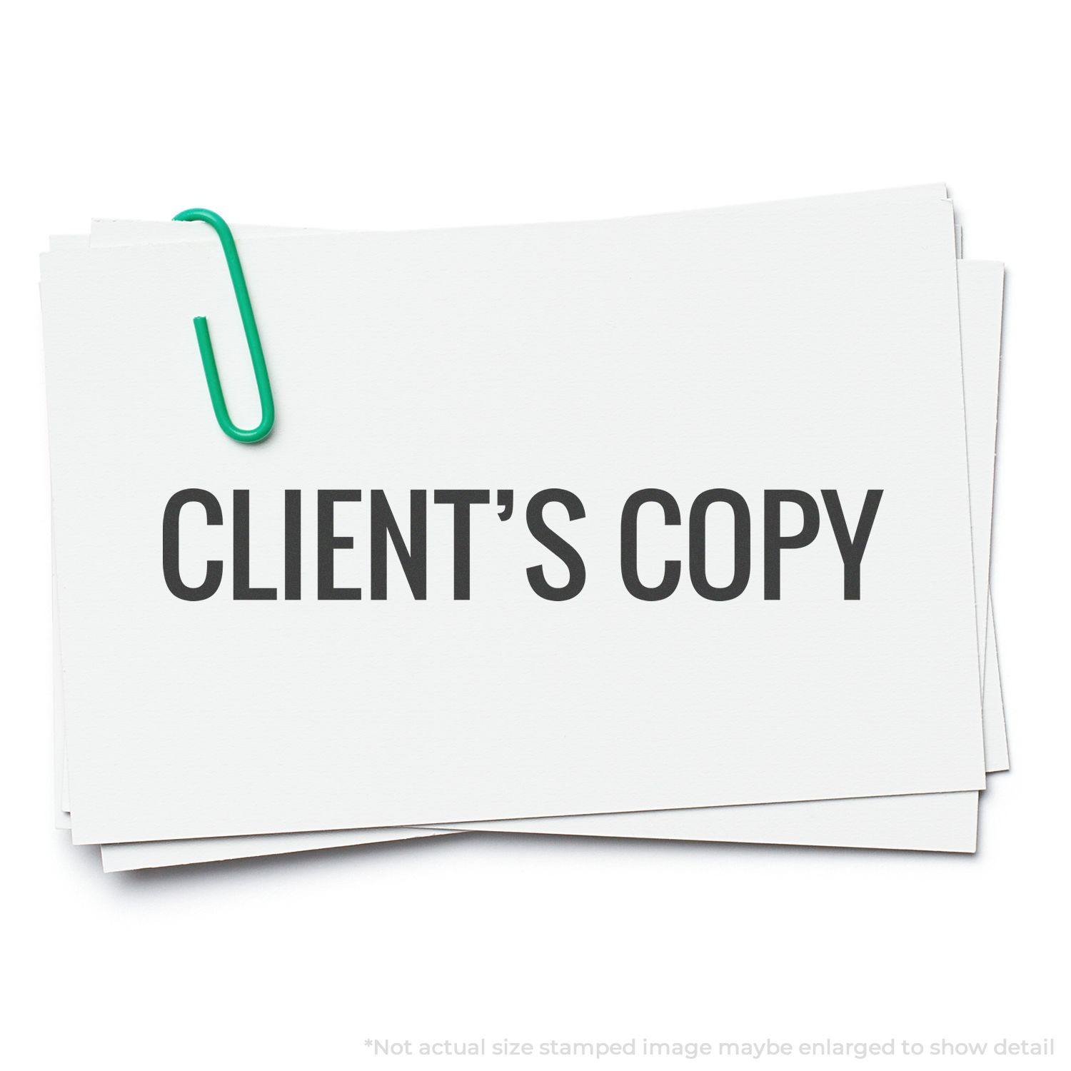 A stack of papers with CLIENT'S COPY stamped on top, secured by a green paperclip. Product: Client's Copy Rubber Stamp.