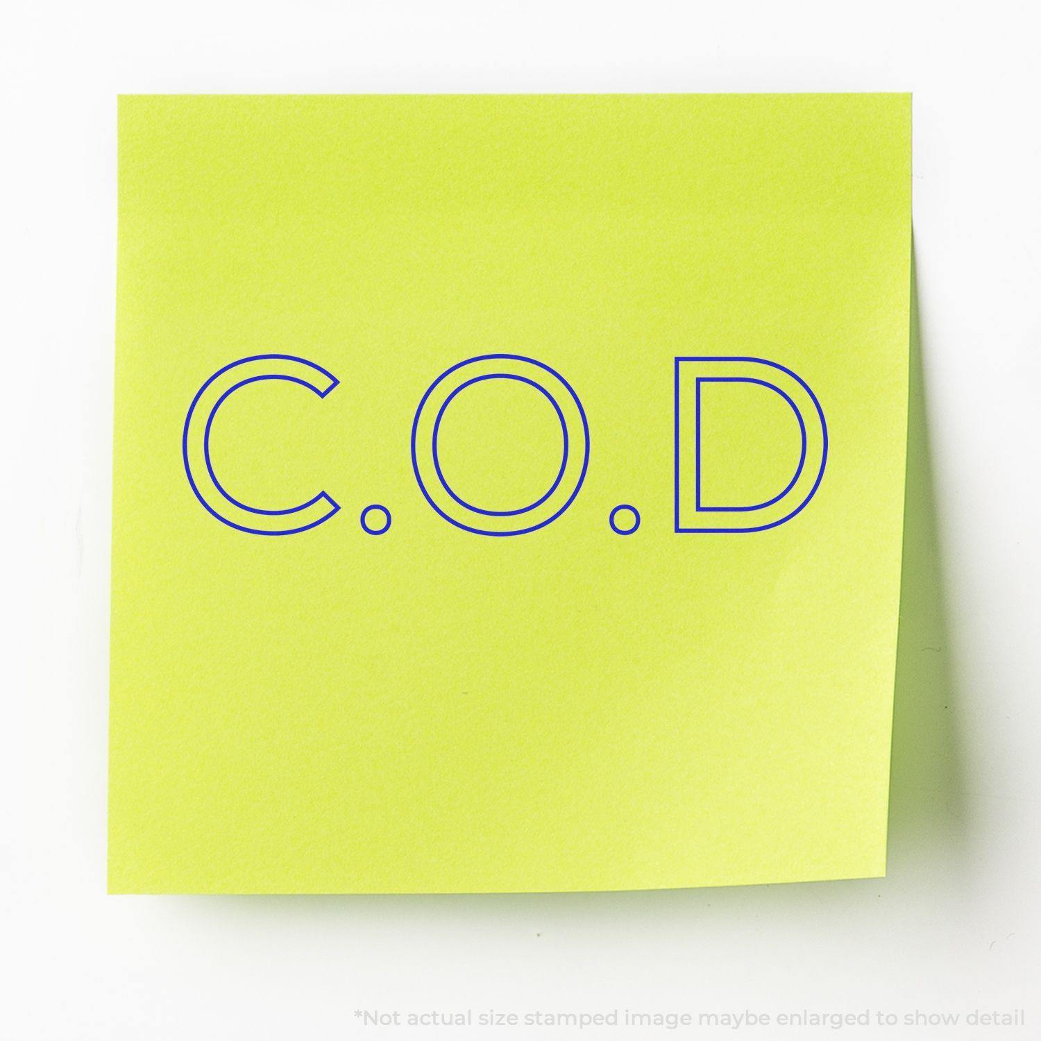 COD Outline Rubber Stamp imprint on a bright yellow sticky note, showcasing the clear and bold blue "C.O.D" text.