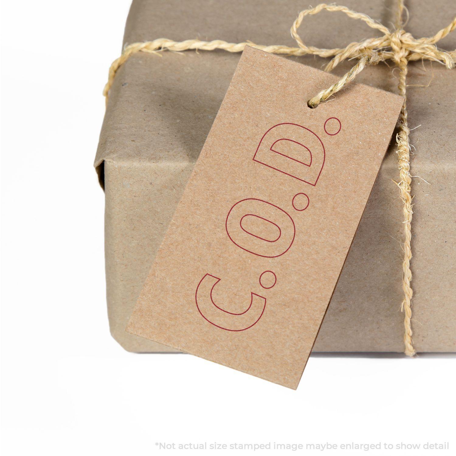 A brown package with a tag stamped C.O.D. using a Slim Pre-Inked COD Stamp With Outline Text, tied with twine.