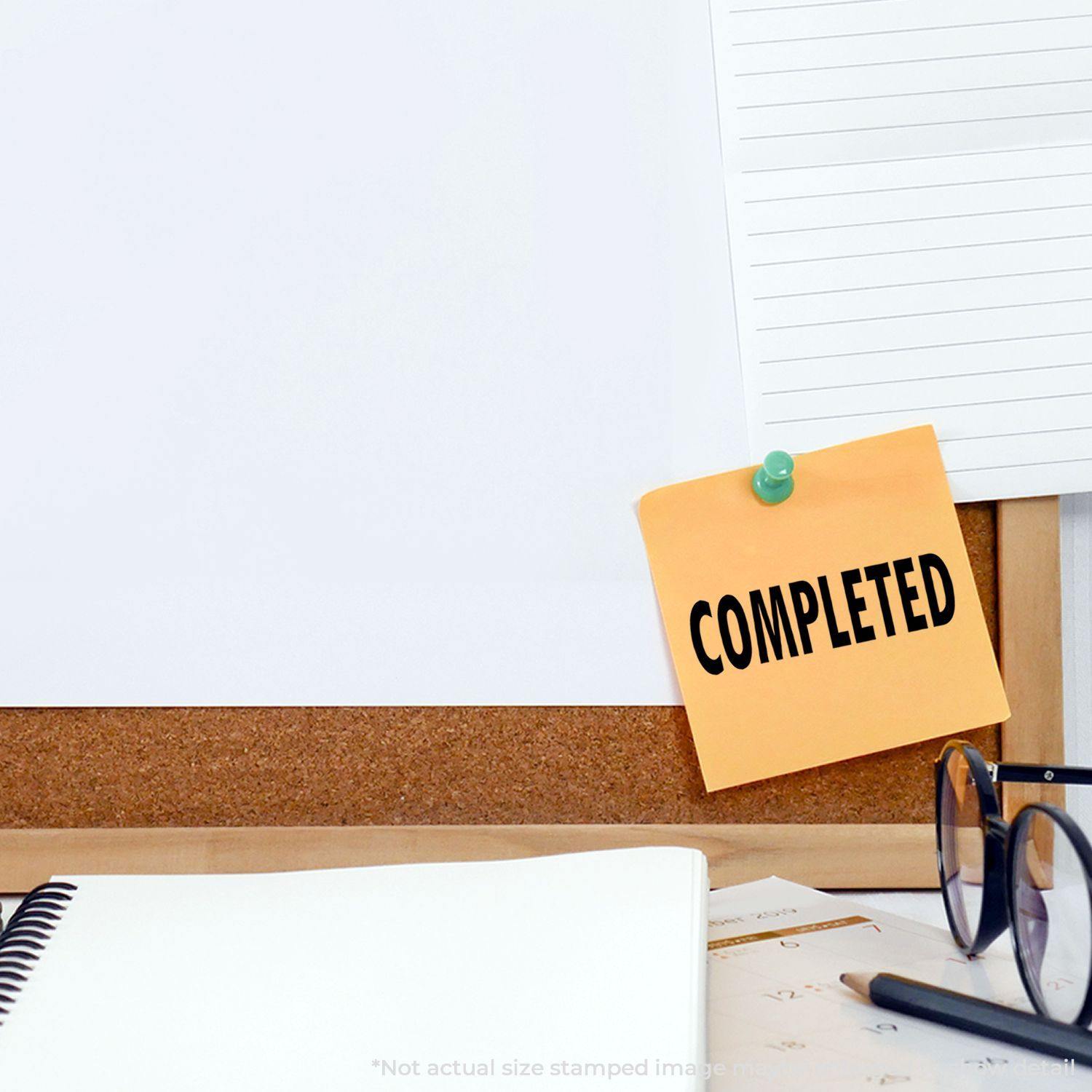 A corkboard with a Completed sticky note, notebook, glasses, and pen. The Completed Rubber Stamp is implied but not shown.