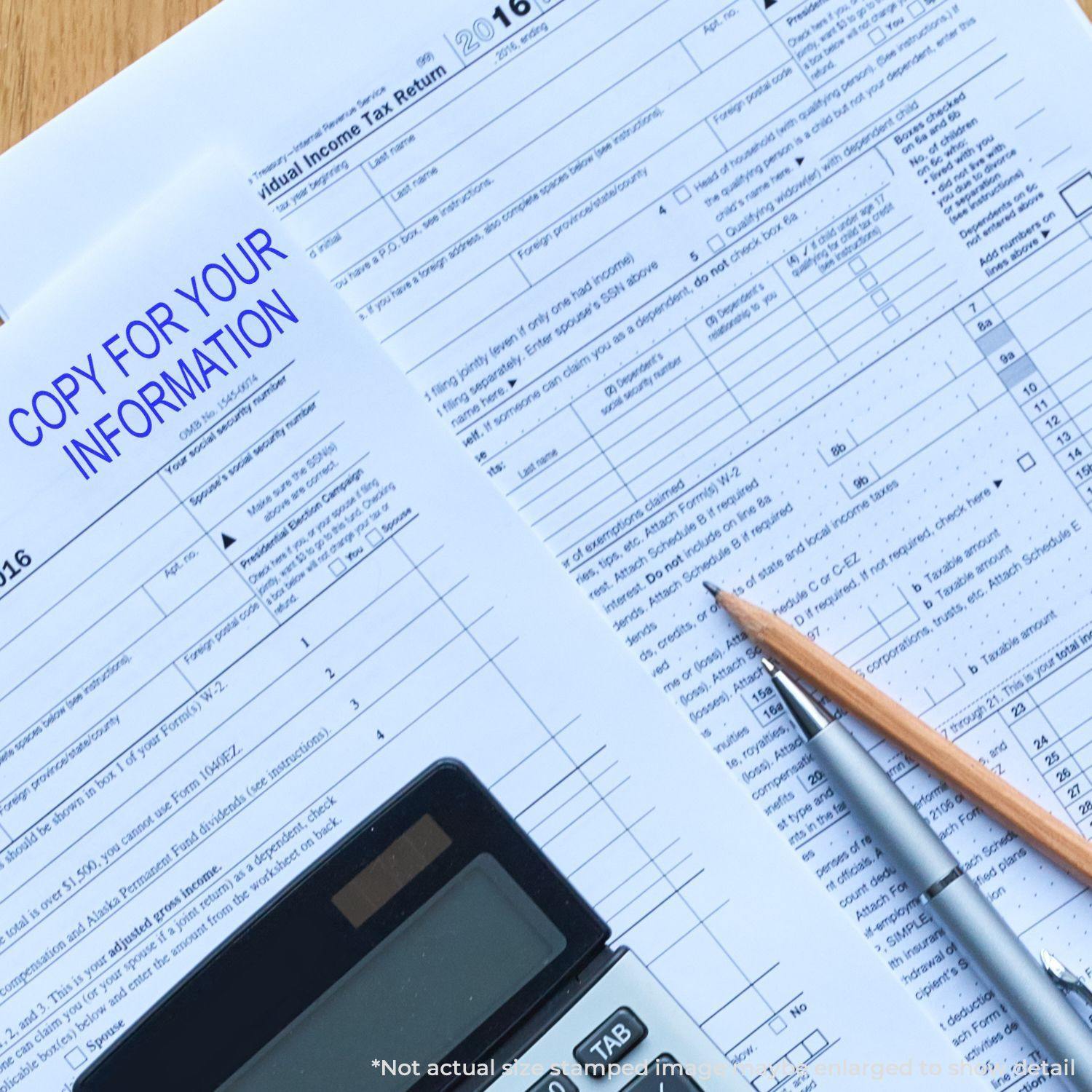 Large Self Inking Copy For Your Information Stamp used on a tax document, with a pencil and calculator nearby.