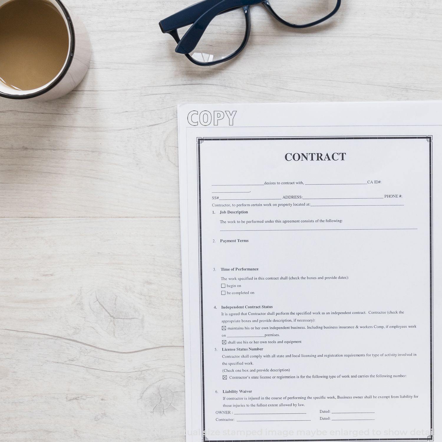 A Self Inking Outline Copy Stamp is used on a contract document placed on a wooden desk with a cup of coffee and glasses nearby.