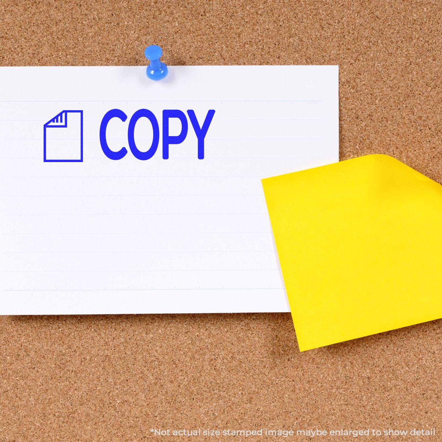 A Large Pre-Inked Copy with Letter Stamp imprinting COPY in blue on a white paper pinned to a corkboard with a yellow sticky note.