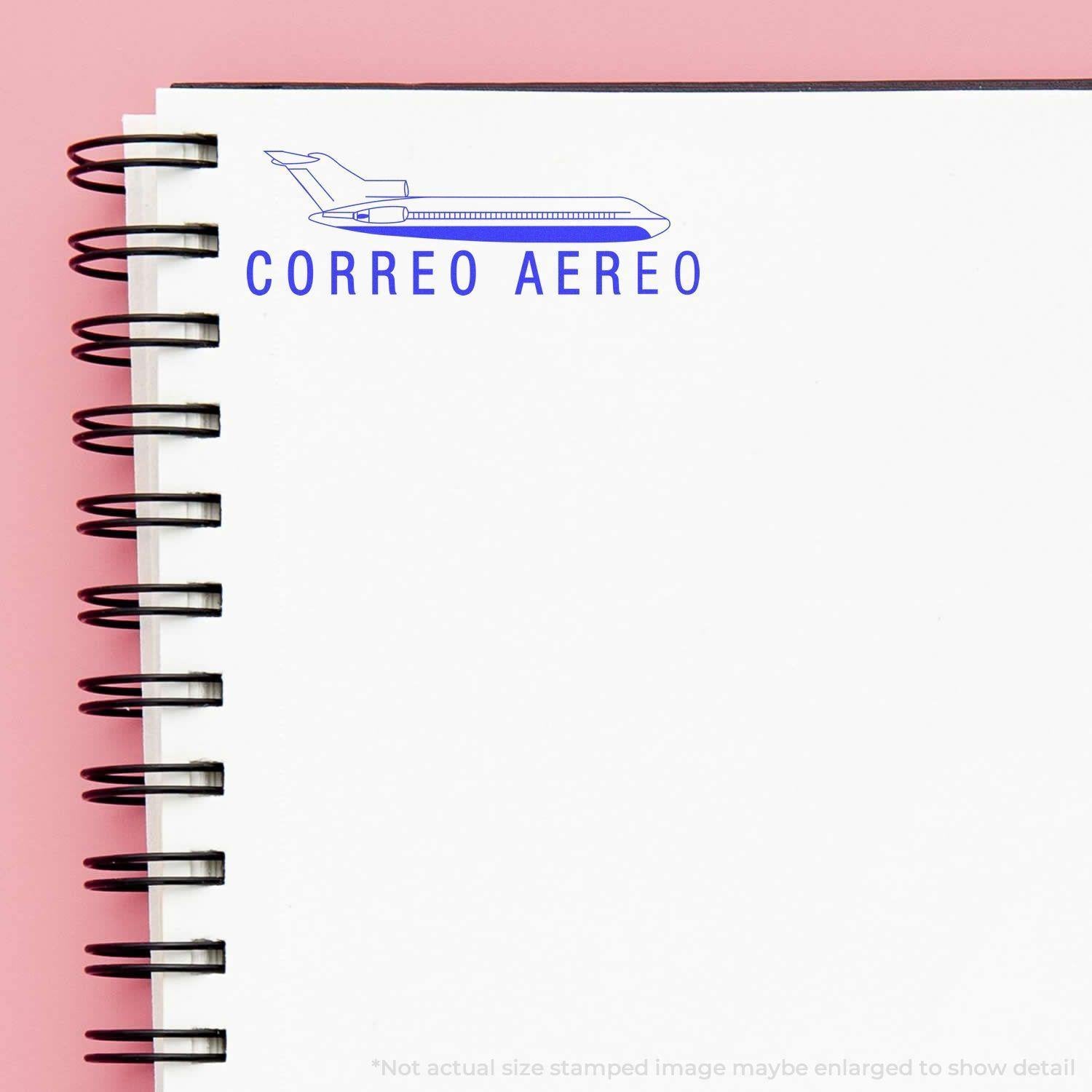 A self-inking stamp with a stamped image showing how the text "CORREO AERO" with an icon of an airplane above the text is displayed after stamping.