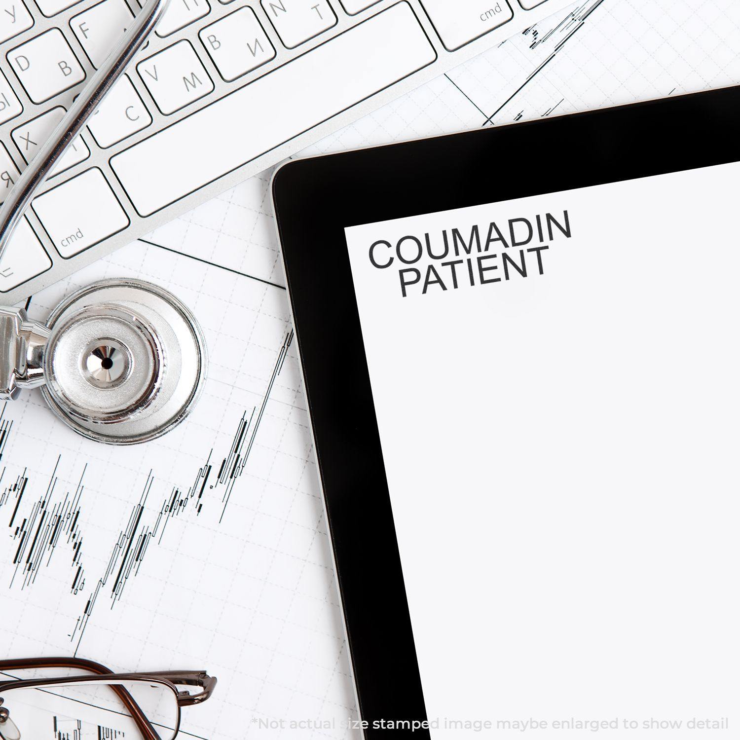 Coumadin Patient Rubber Stamp used on a document next to a stethoscope, glasses, and a keyboard on a desk.