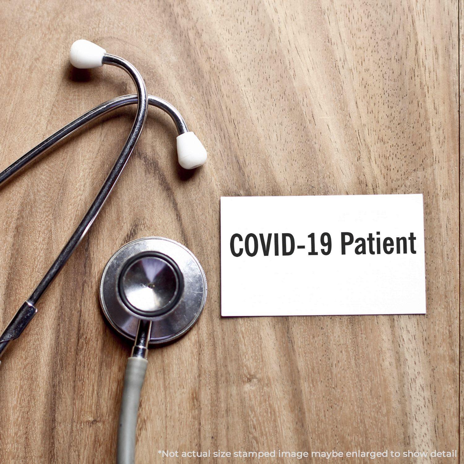 Stethoscope on wooden surface next to a card labeled COVID-19 Patient stamped with a Slim Pre-Inked Covid-19 Patient Stamp.