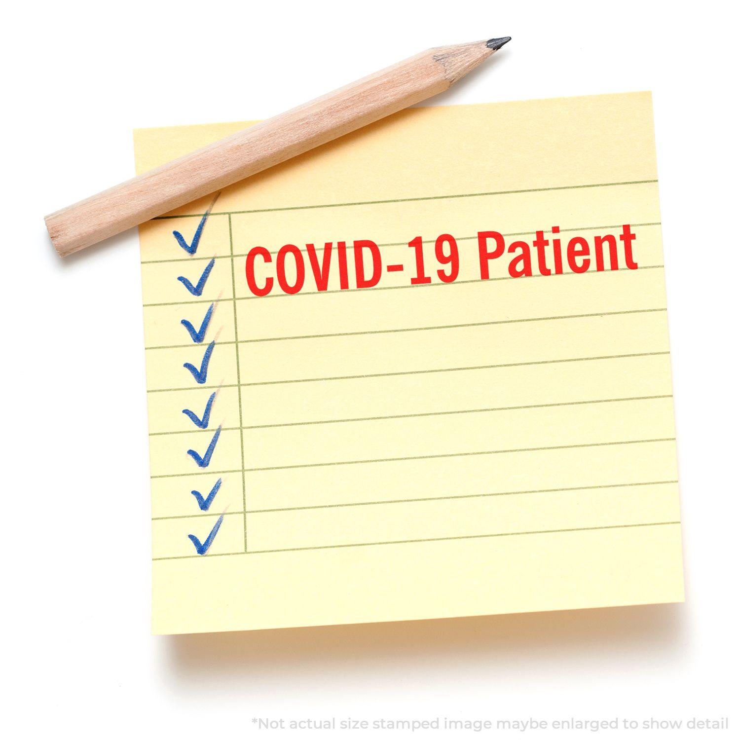 Yellow sticky note with blue checkmarks and COVID-19 Patient stamped in red using the Large Covid-19 Patient Rubber Stamp, pencil on top.