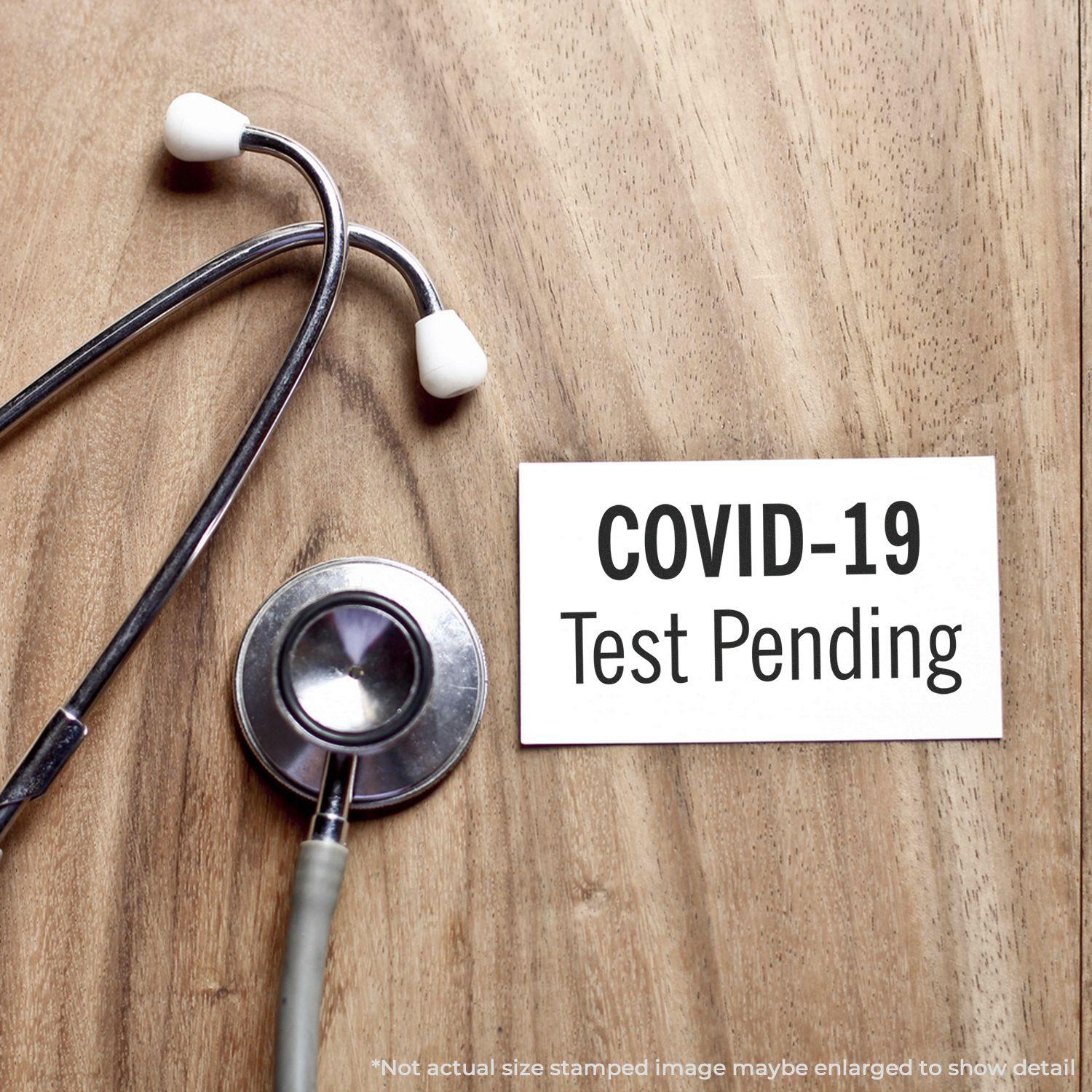 A stock office rubber stamp with a stamped image showing how the text "COVID-19 Test Pending" is displayed after stamping.