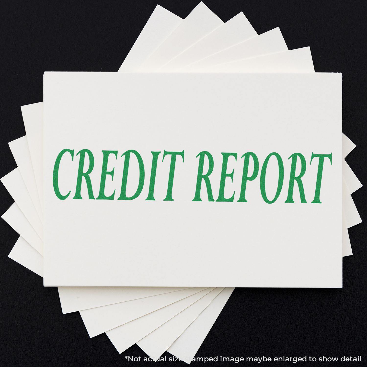 Credit Report Rubber Stamp in green ink on a stack of white papers, displayed on a black background.