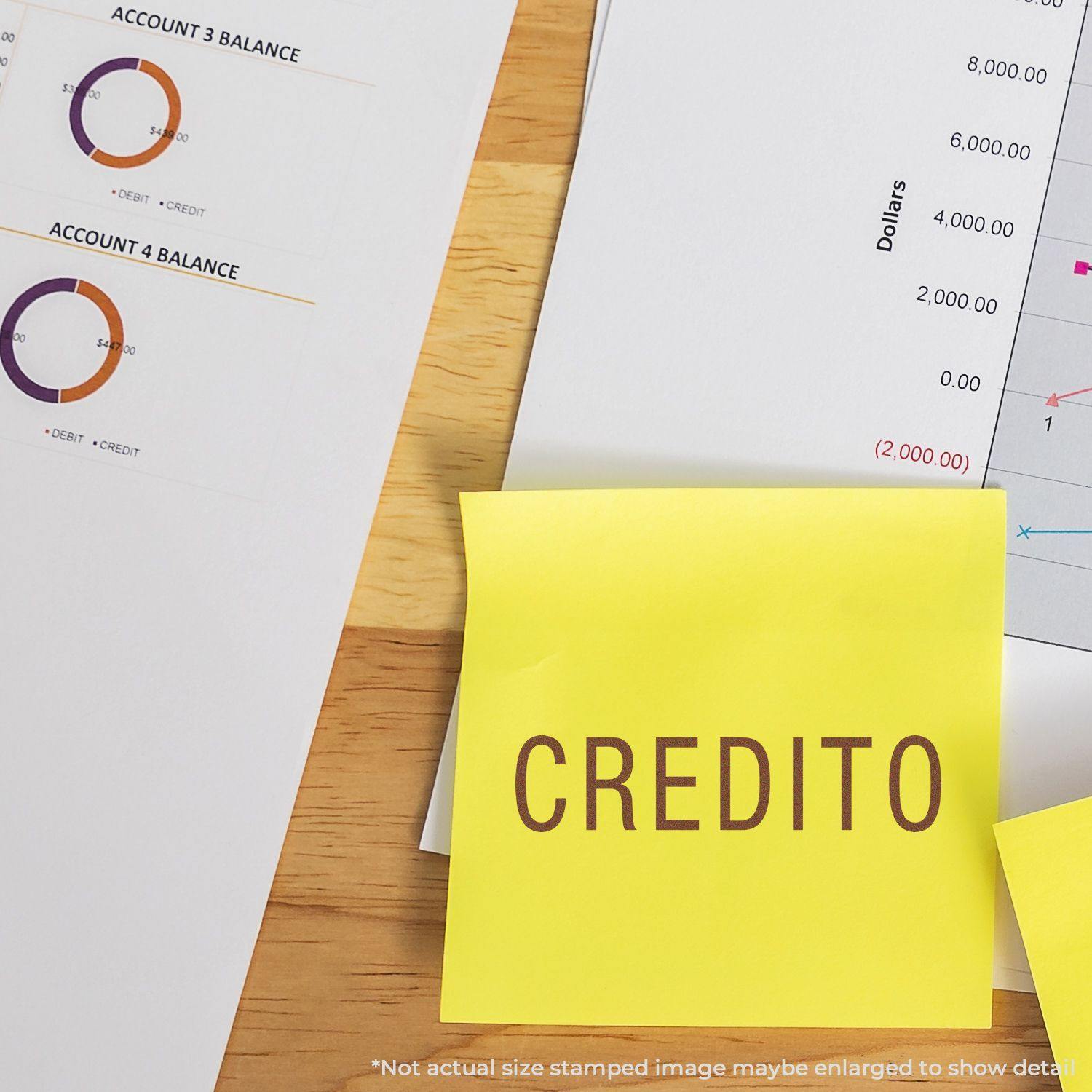 Self Inking Credito Stamp used on a yellow sticky note, placed on a desk with financial charts and documents in the background.