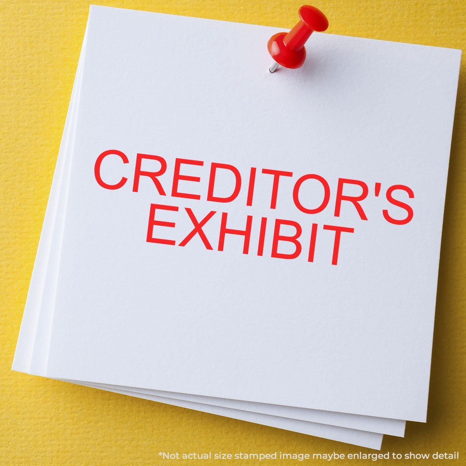 Large Pre-Inked Creditors Exhibit Stamp in red ink on white paper, pinned with a red pushpin on a yellow background.