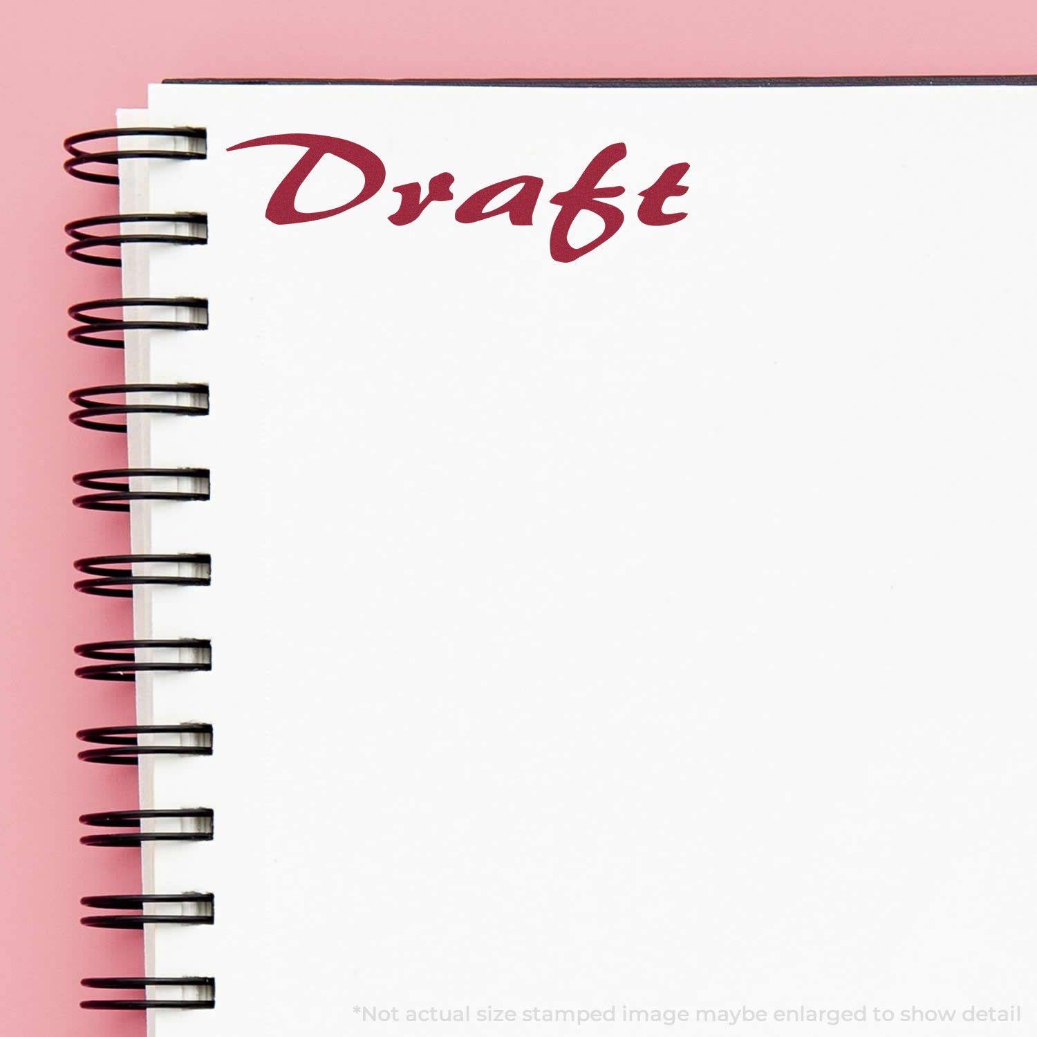 A notebook with a spiral binding and a Draft mark in red ink at the top left corner, stamped using the Large Cursive Draft Rubber Stamp.