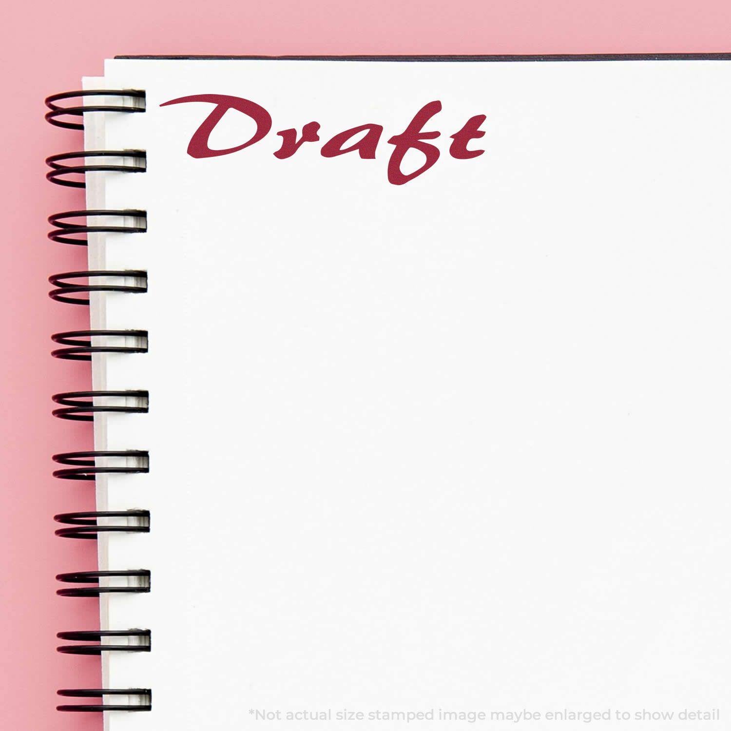 A stock office rubber stamp with a stamped image showing how the text "Draft" in a cursive font is displayed after stamping.