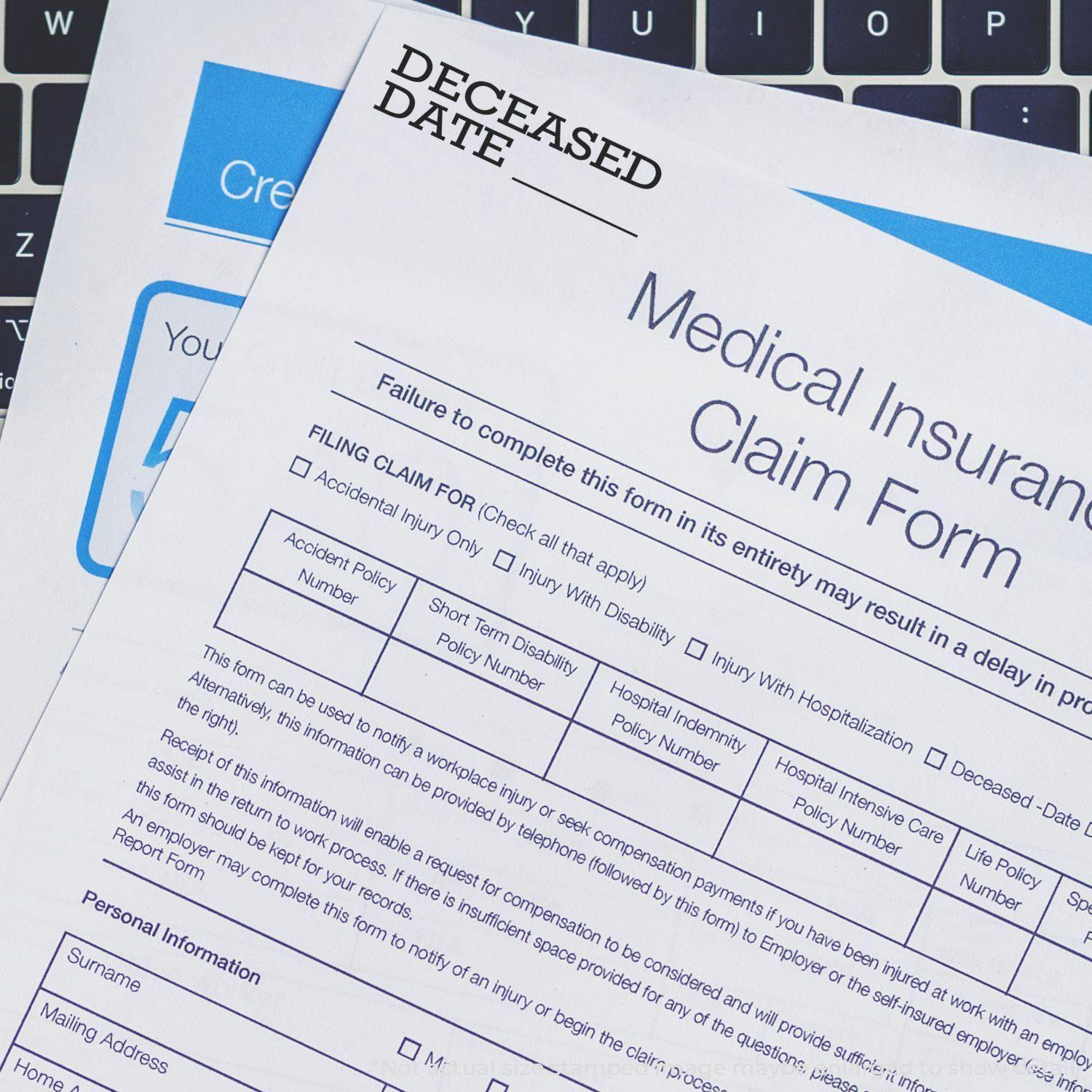 Medical insurance claim form stamped with Deceased Date using the Self Inking Deceased Date Stamp, placed on a keyboard.