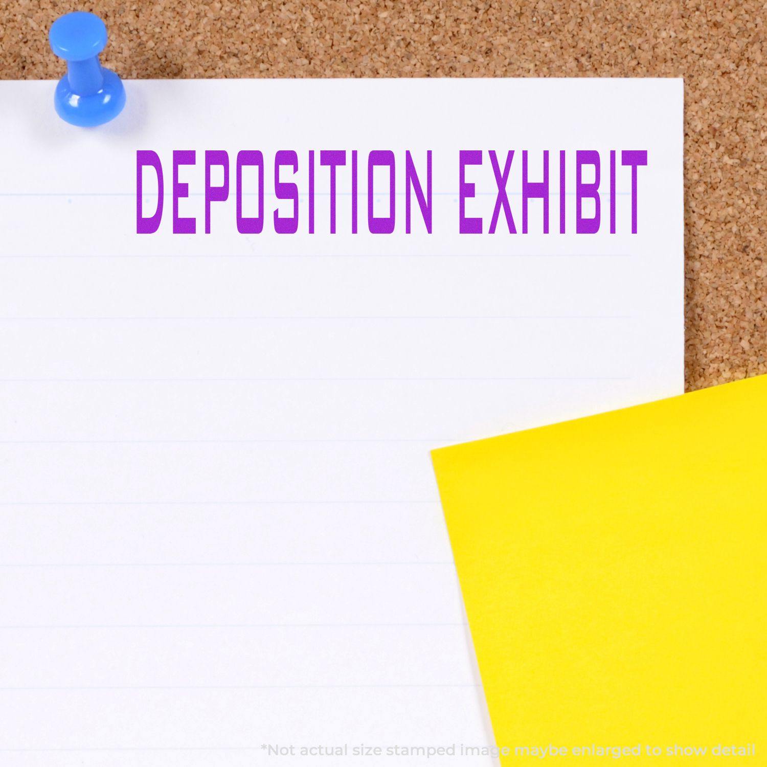 Large Deposition Exhibit Rubber Stamp used on a white paper pinned to a corkboard, with a yellow paper beside it.