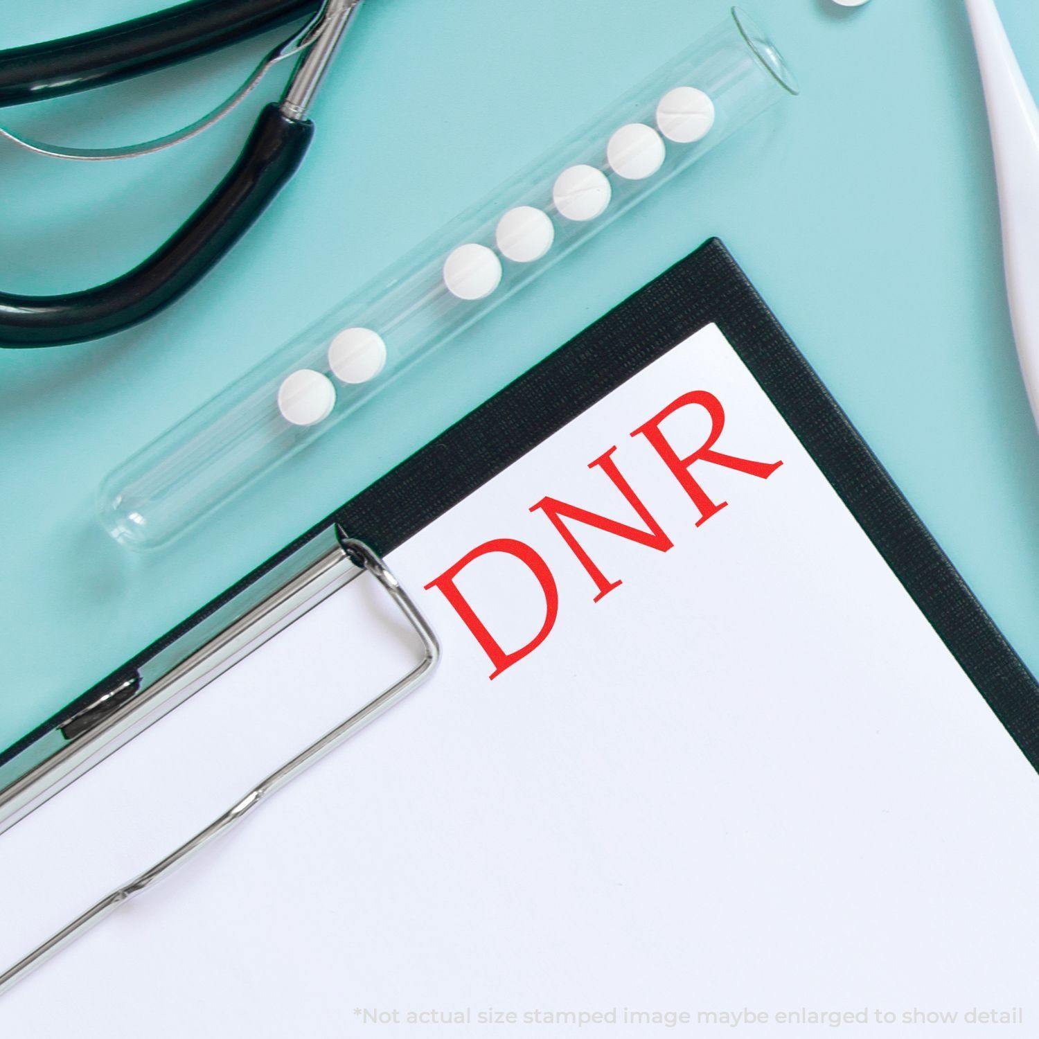 Clipboard with DNR stamped in red using the Large Pre-Inked DNR Stamp, surrounded by medical tools on a light blue background.