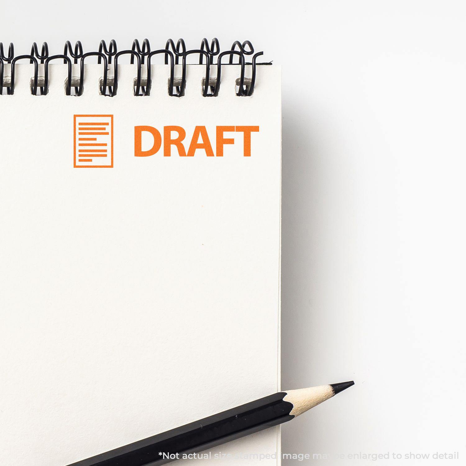 A notebook with a Draft with Letter Rubber Stamp imprint in orange on the top left corner, next to a black pencil.