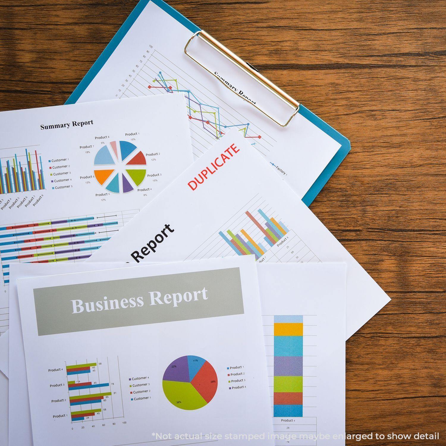 Several business reports on a wooden desk, one stamped with DUPLICATE using a Duplicate Rubber Stamp.