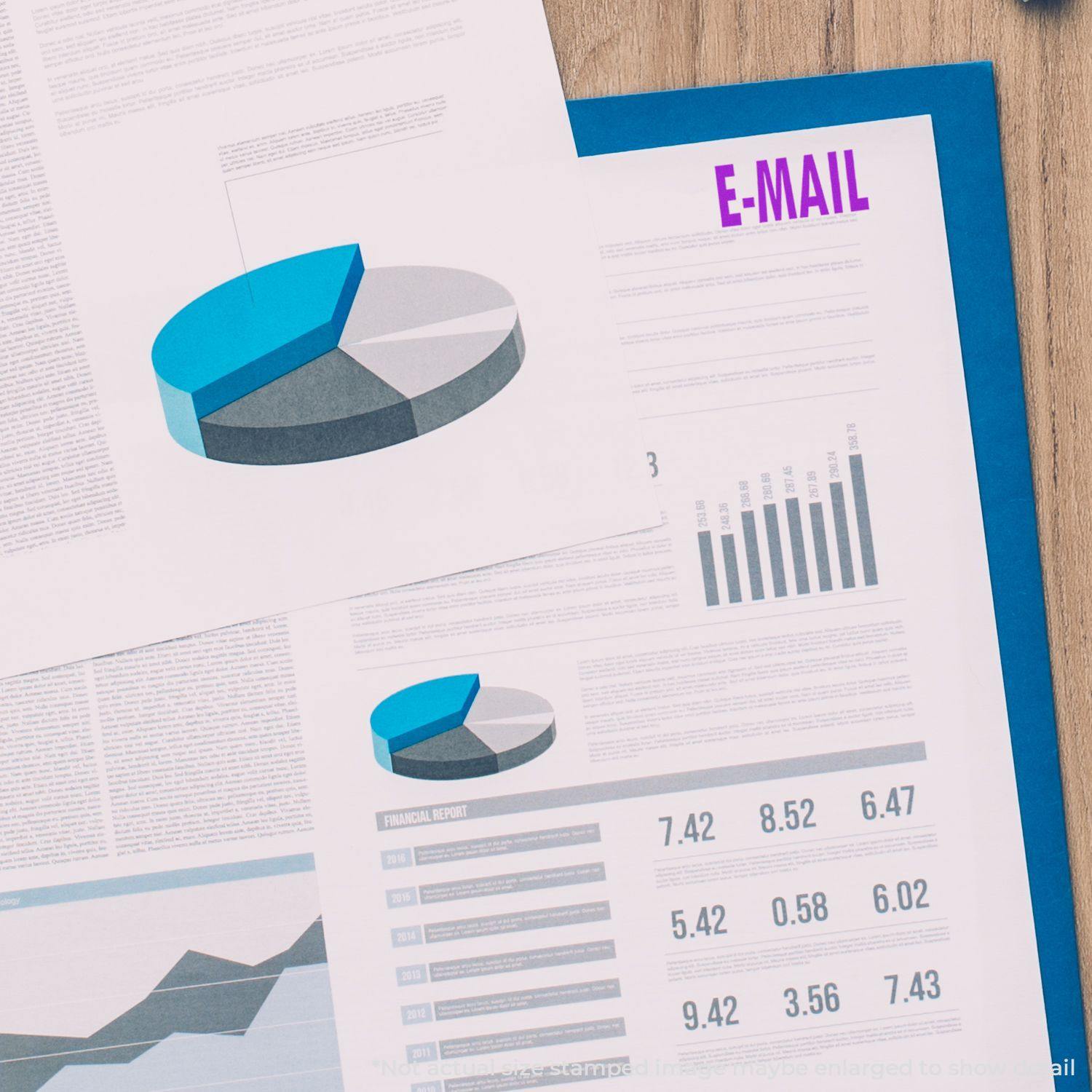 Slim Pre-Inked E-Mail Stamp marking E-MAIL in purple on a financial report with charts and graphs on a wooden desk.