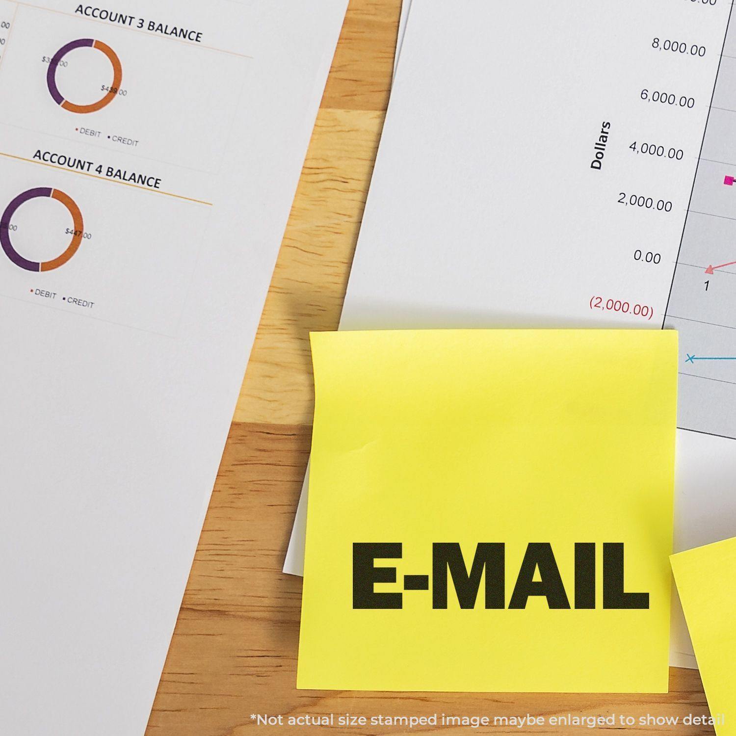 Self Inking E-Mail Stamp used on a yellow sticky note, placed on a desk with financial documents and charts.