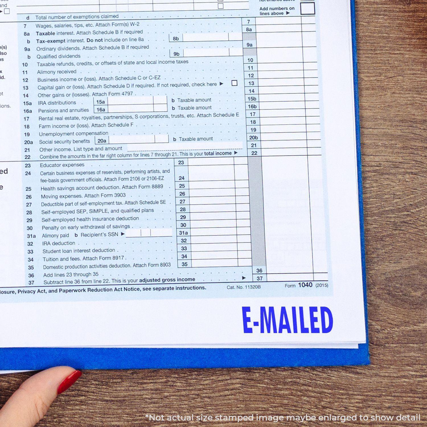 A hand holding a tax form with a blue E-MAILED mark from the Large Self Inking E Mailed Stamp at the bottom right corner.