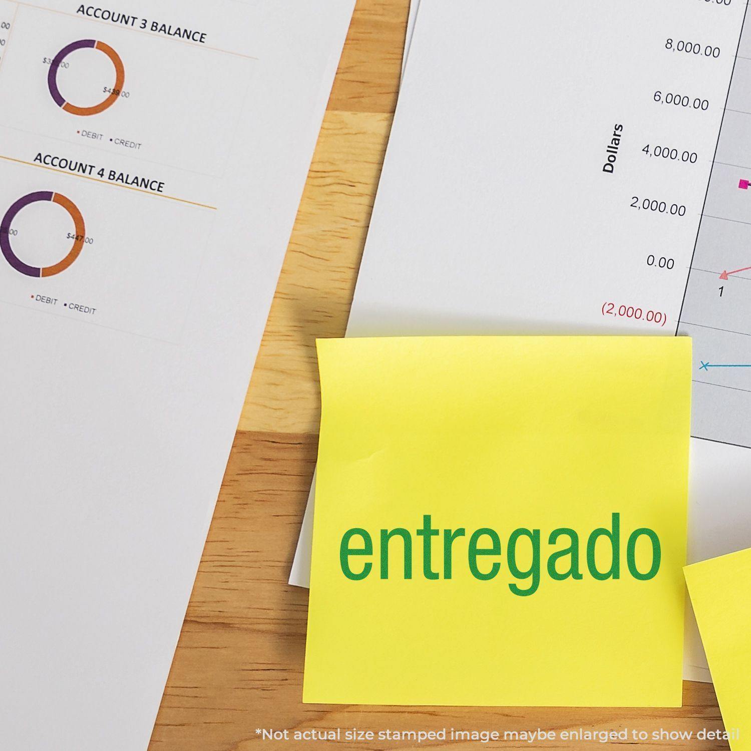 Slim Pre-Inked Entregado Stamp used on a yellow sticky note placed on a desk with financial documents in the background.