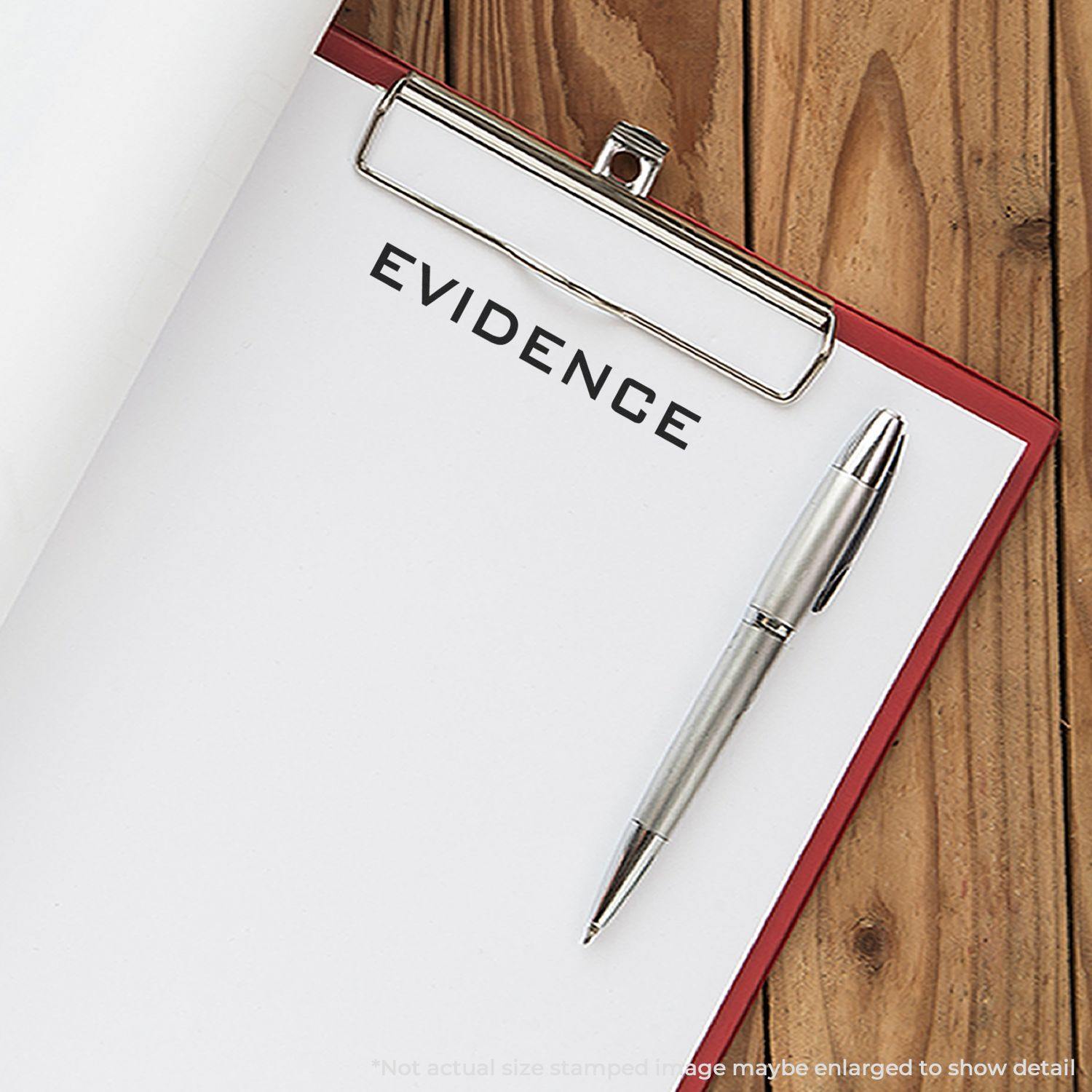 A clipboard with a stamped paper labeled EVIDENCE using the Large Evidence Rubber Stamp, alongside a silver pen on a wooden surface.