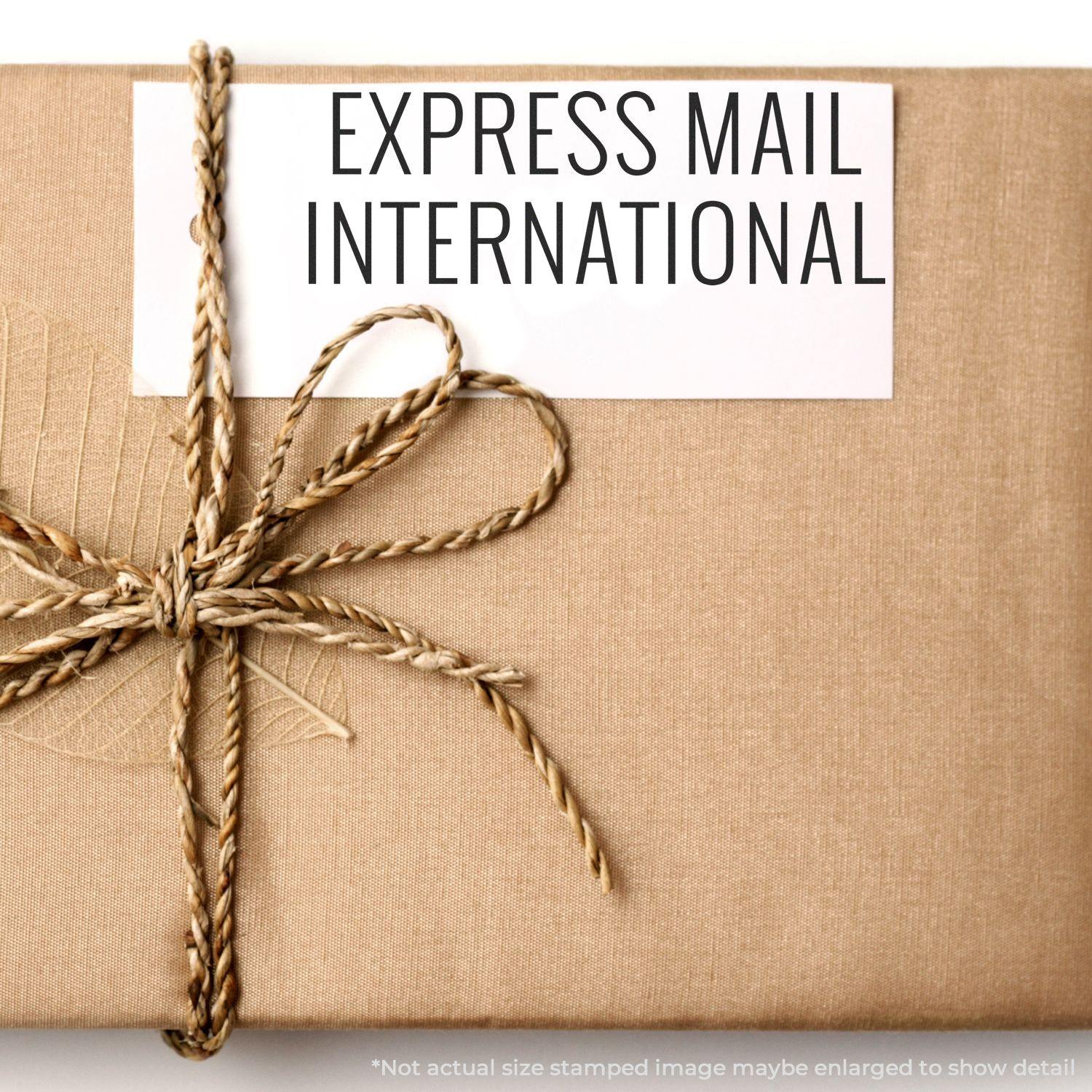 A package wrapped in brown paper and twine, stamped with EXPRESS MAIL INTERNATIONAL using the Large Express Mail International Rubber Stamp.