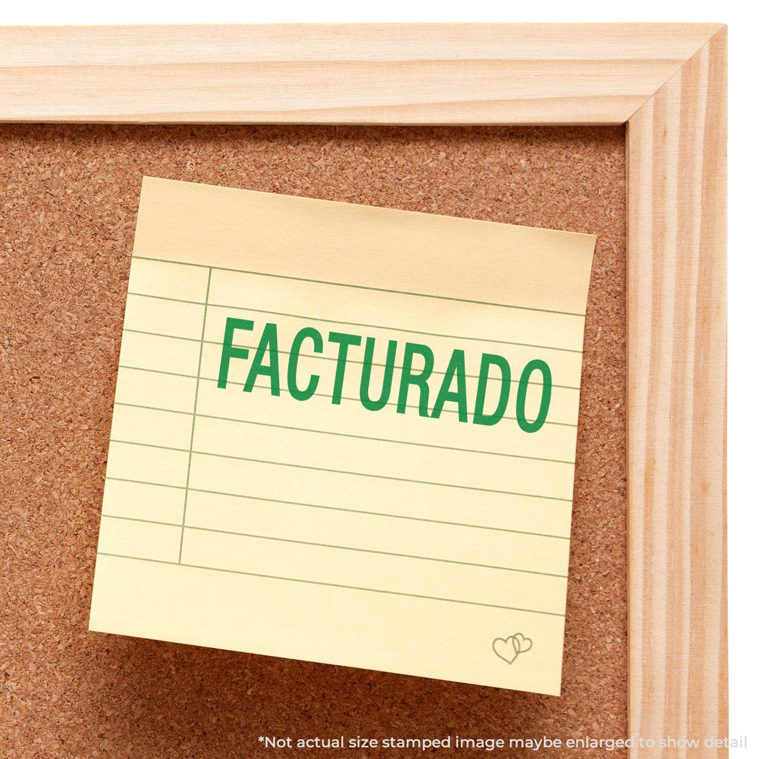 A corkboard with a sticky note stamped FACTURADO in green ink using the Large Facturado Rubber Stamp.