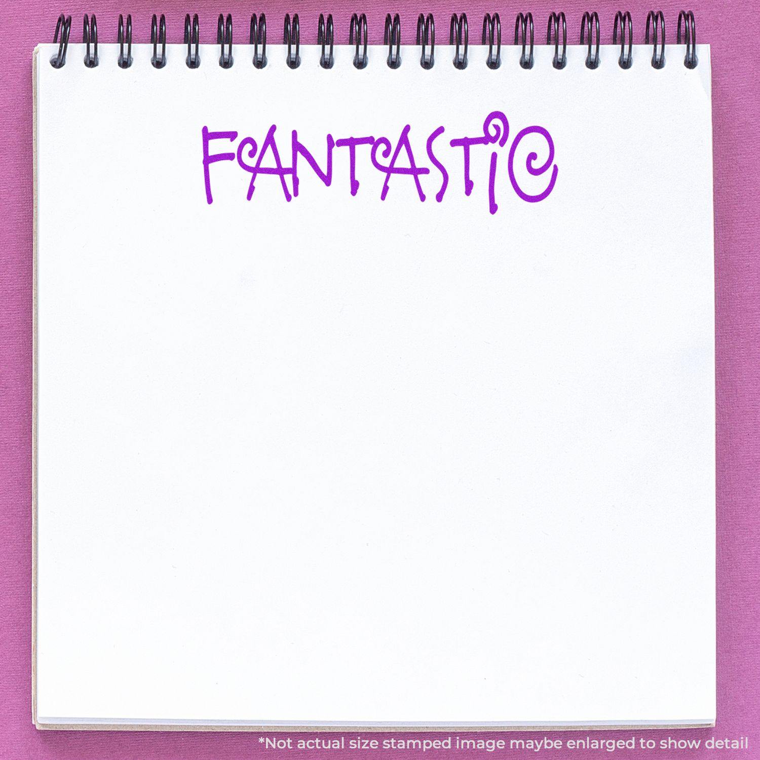 A notebook with the word Fantastic stamped on a page using the Large Fantastic Rubber Stamp, with a green background and red pen visible.