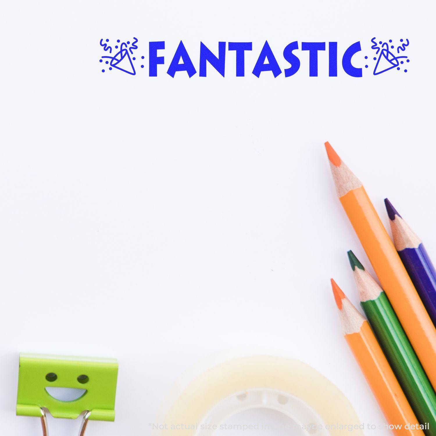 Large Self Inking Fantastic with Icons Stamp in blue ink on white paper, surrounded by colorful pencils, a smiling binder clip, and tape.