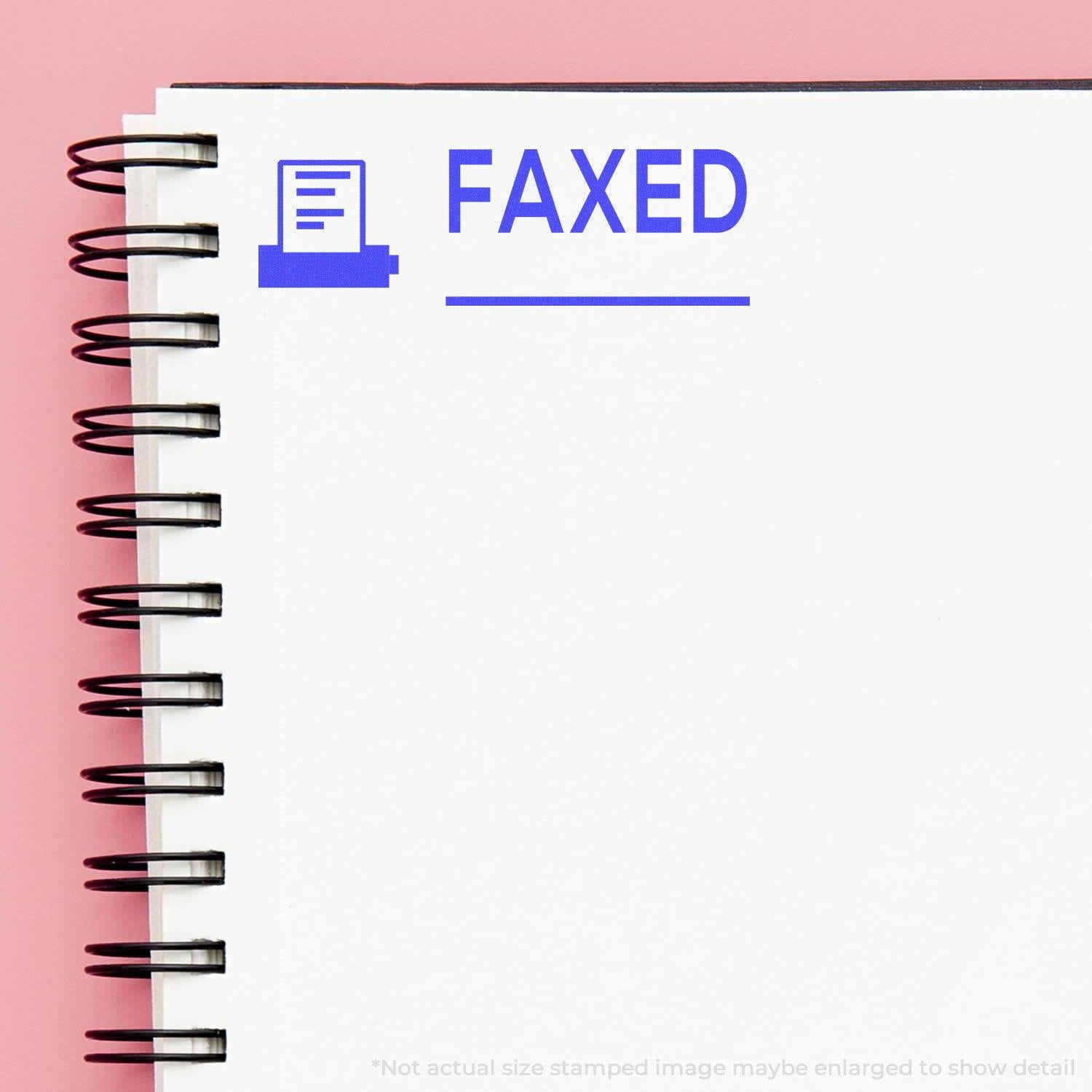 A self-inking stamp with a stamped image showing how the text "FAXED" with a small image of a fax machine on the left and a line underneath the text is displayed after stamping.