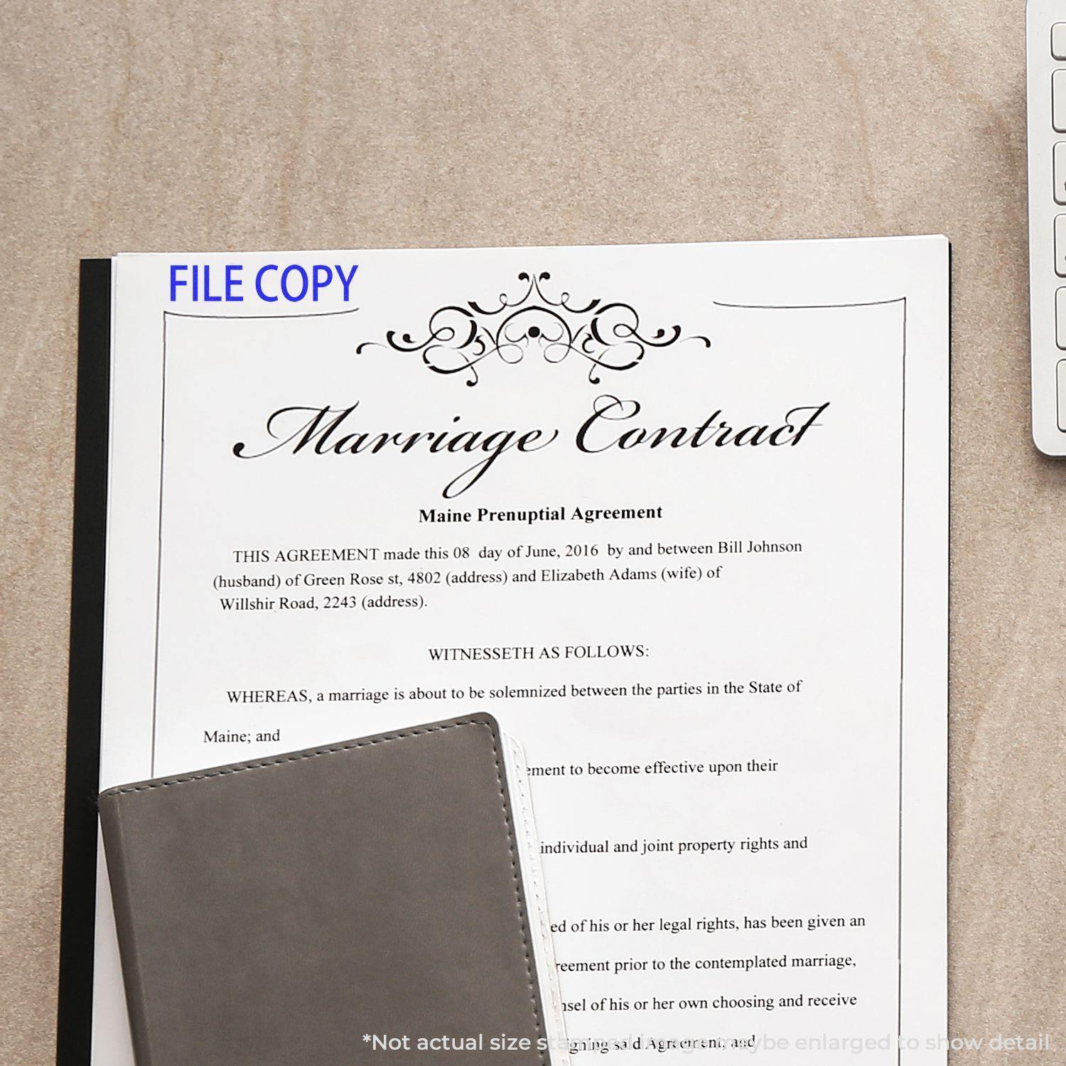 A File Copy Rubber Stamp is used on a marriage contract document placed on a desk with a notebook and a keyboard nearby.