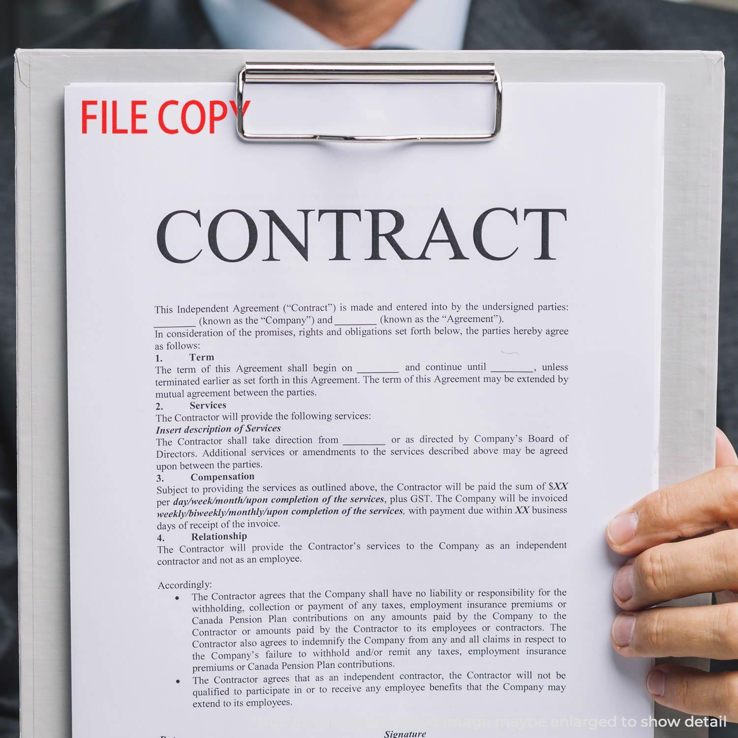 A clipboard with a contract document stamped FILE COPY using the File Copy Rubber Stamp, held by a person in a suit.