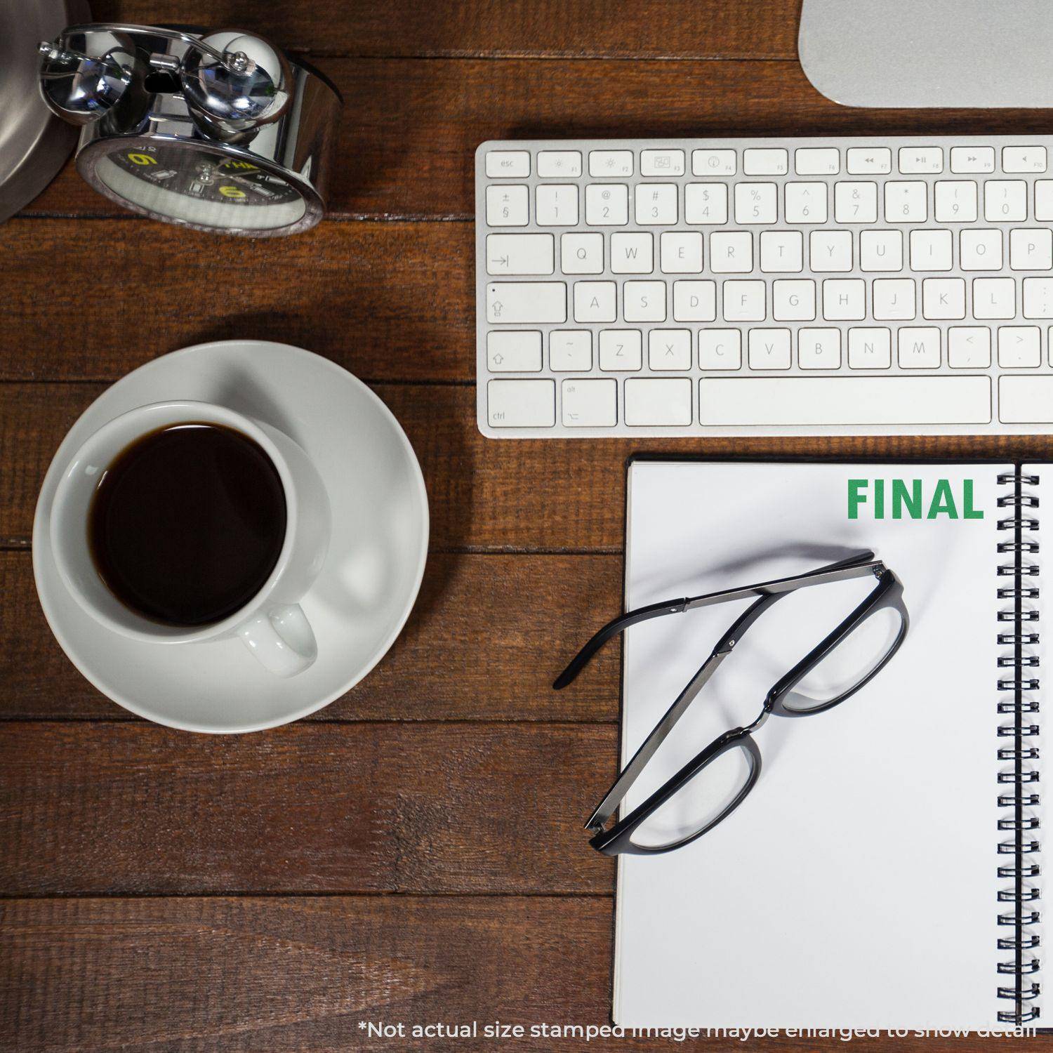 A desk with a keyboard, coffee, glasses, and a notebook stamped with FINAL using the Large Pre-Inked Final Stamp.