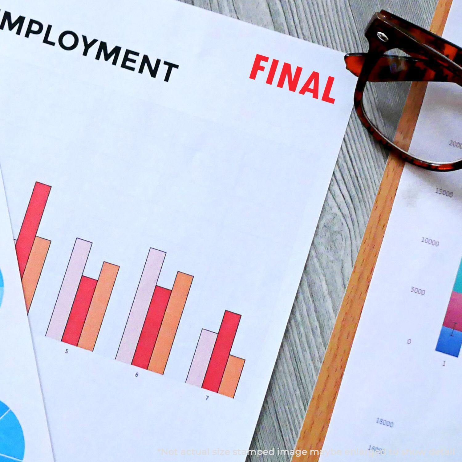 Self Inking Final Stamp used on a document with charts and graphs, next to eyeglasses on a wooden surface.