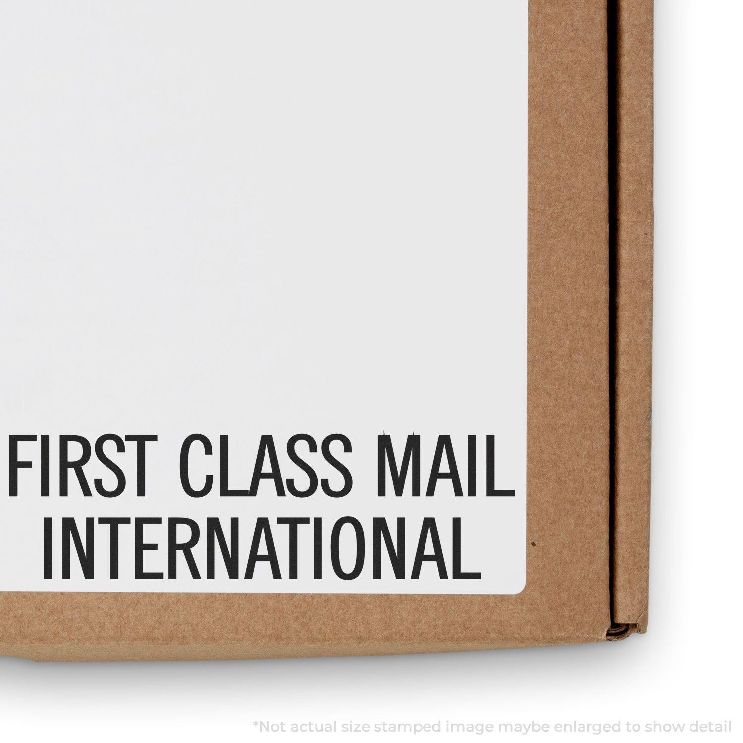 Slim Pre-Inked First Class Mail International Stamp on a cardboard box, with bold black text on a white label.