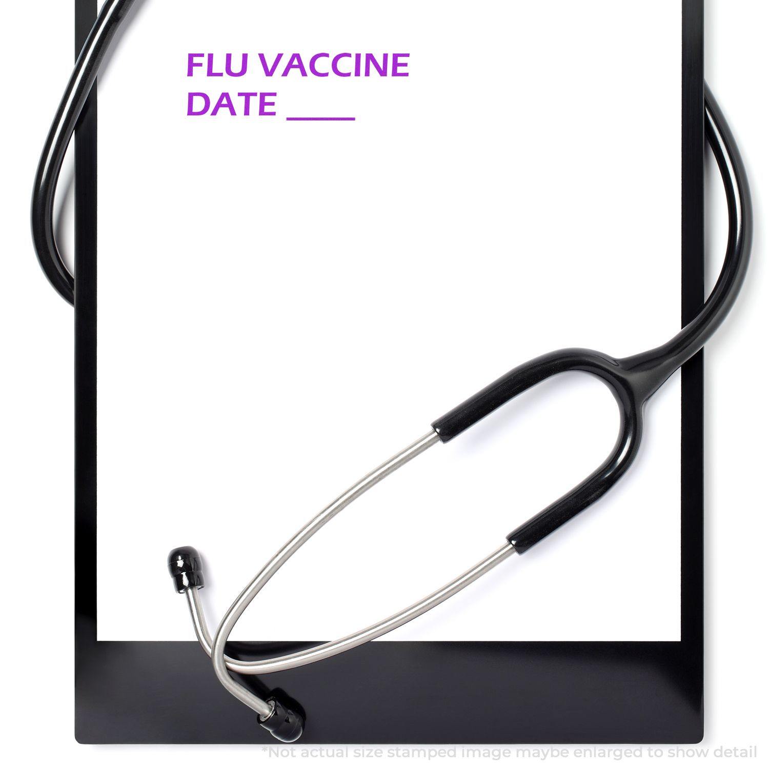 A stethoscope rests on a clipboard with a paper labeled FLU VACCINE DATE ___ stamped using the Large Self Inking Flu Vaccine Date Stamp.