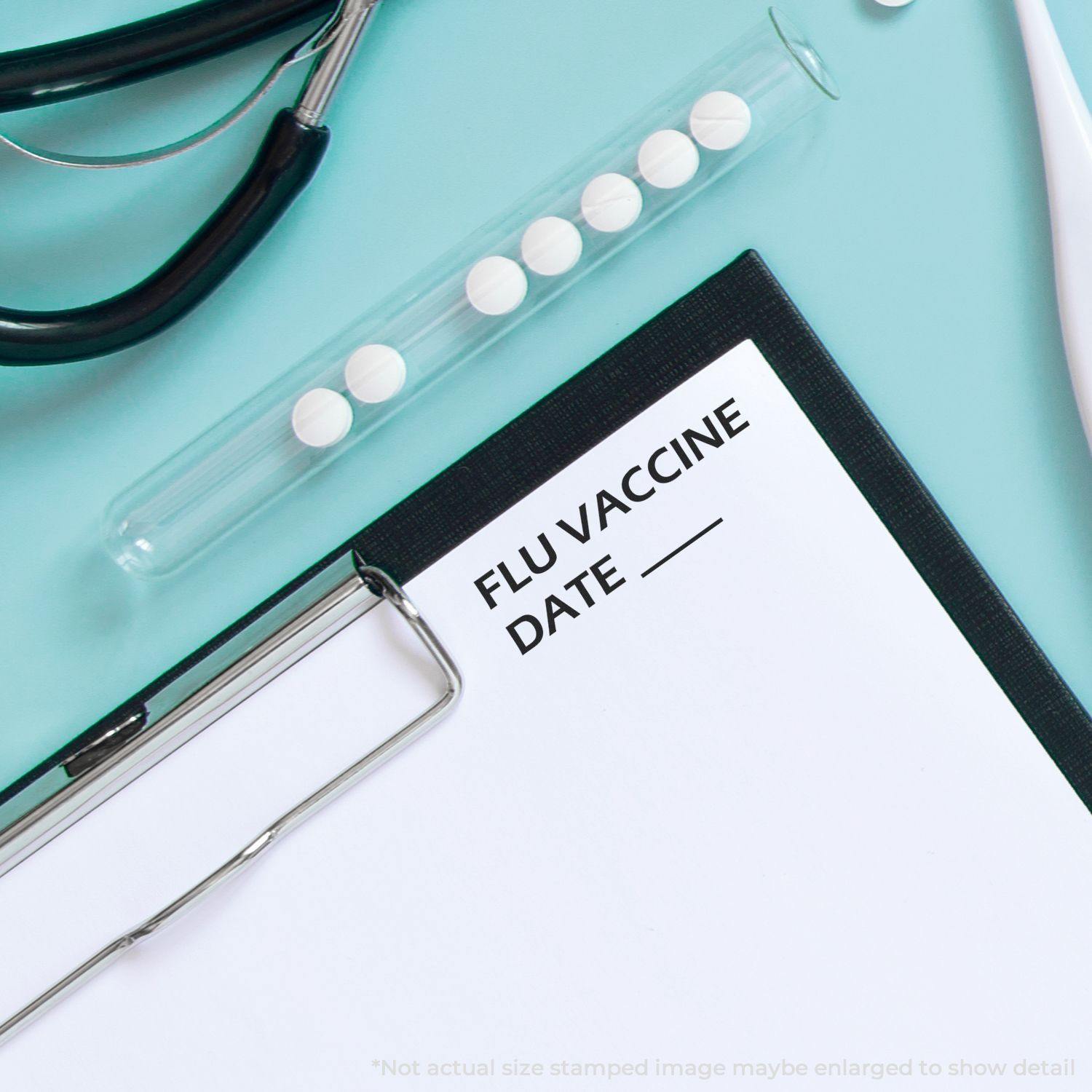 Self Inking Flu Vaccine Date Stamp used on a clipboard with a stethoscope, test tube with pills, and thermometer on a light blue background.