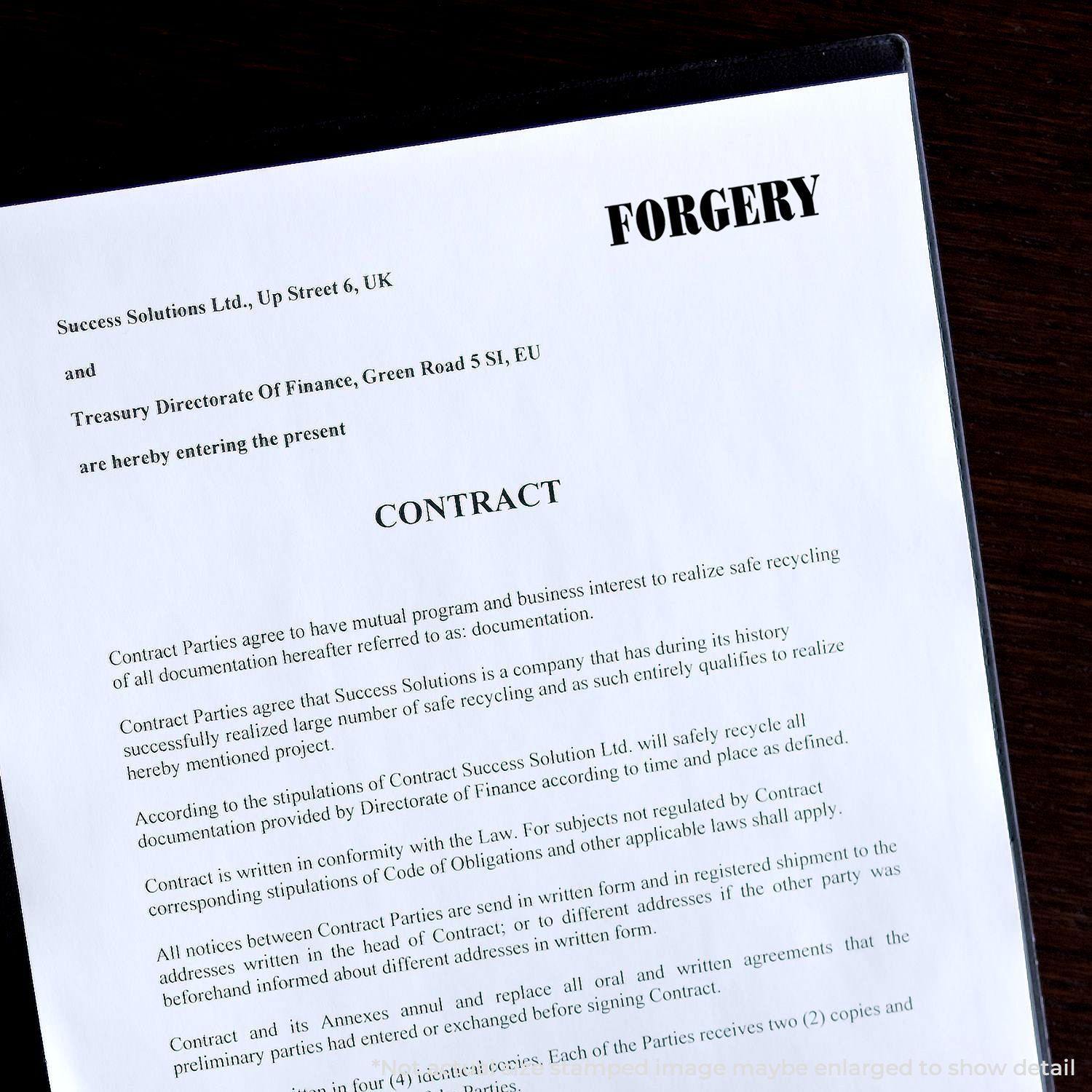 A document stamped with Forgery using the Self Inking Bank Forgery Stamp, highlighting the word Contract on a white paper.