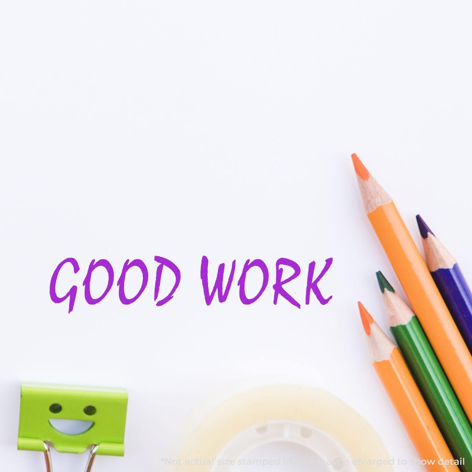 Large Self Inking Good Work Stamp impression in purple ink on white paper, surrounded by colorful pencils, a smiling clip, and tape.