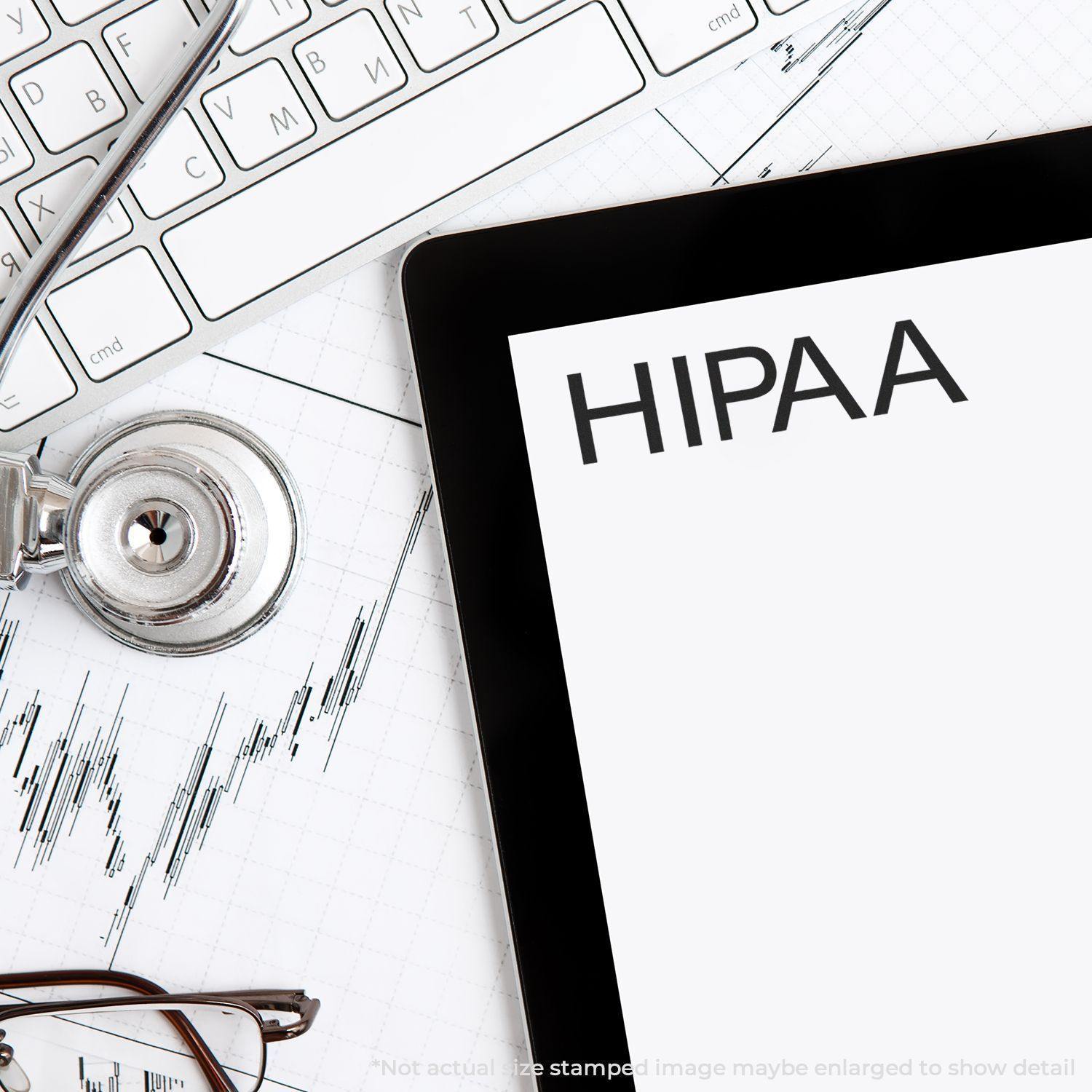 Slim Pre-Inked HIPAA Stamp next to a stethoscope, keyboard, and tablet displaying HIPAA on a medical chart background.