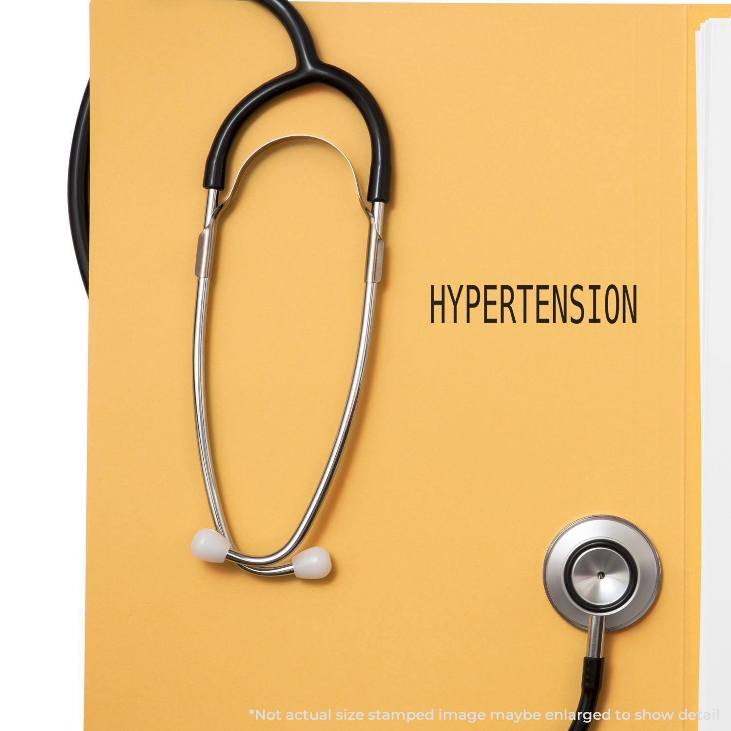 A Large Self Inking Hypertension Stamp marks a yellow folder with a stethoscope beside it.