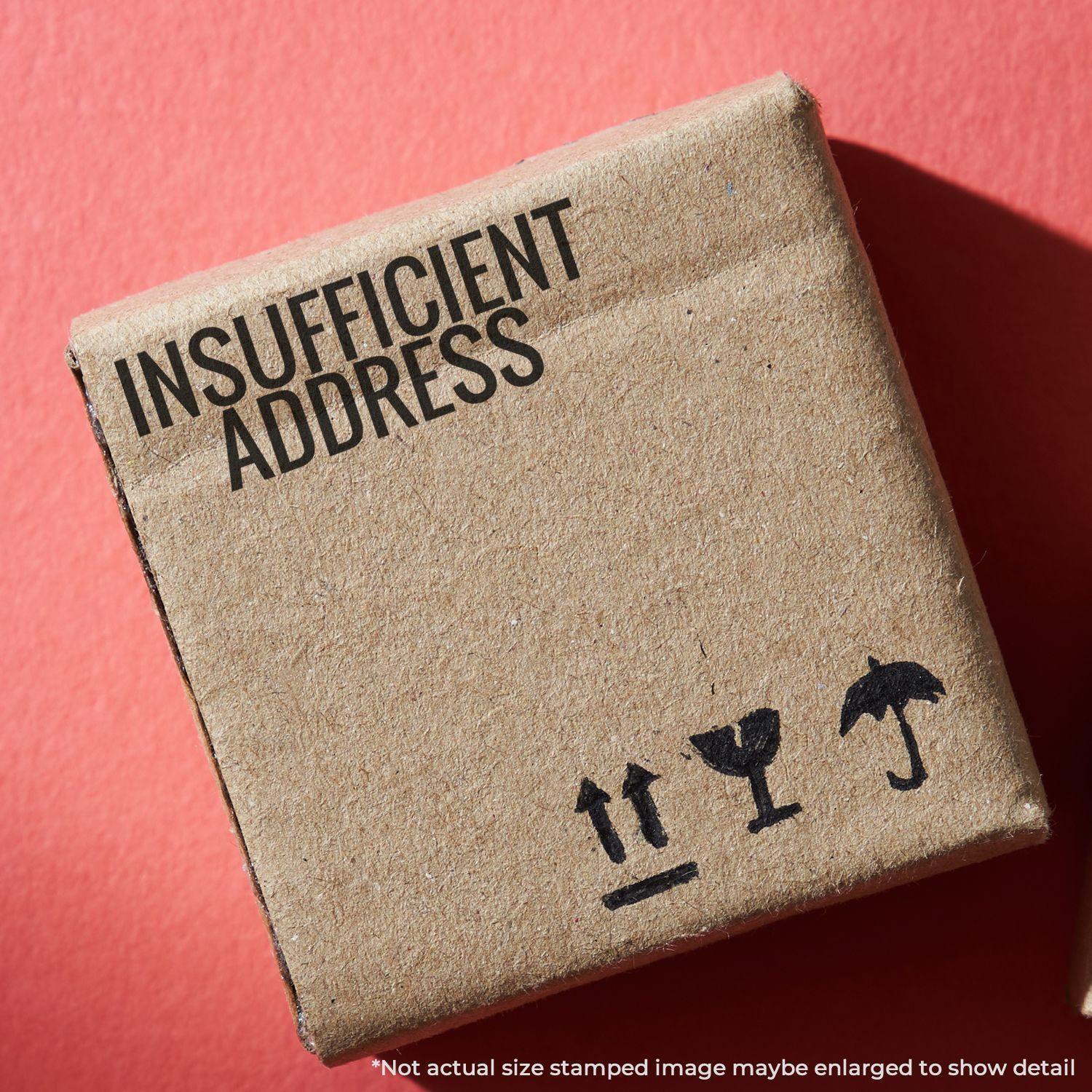 A cardboard box stamped with Insufficient Address using the Insufficient Address Rubber Stamp, placed on a red background.