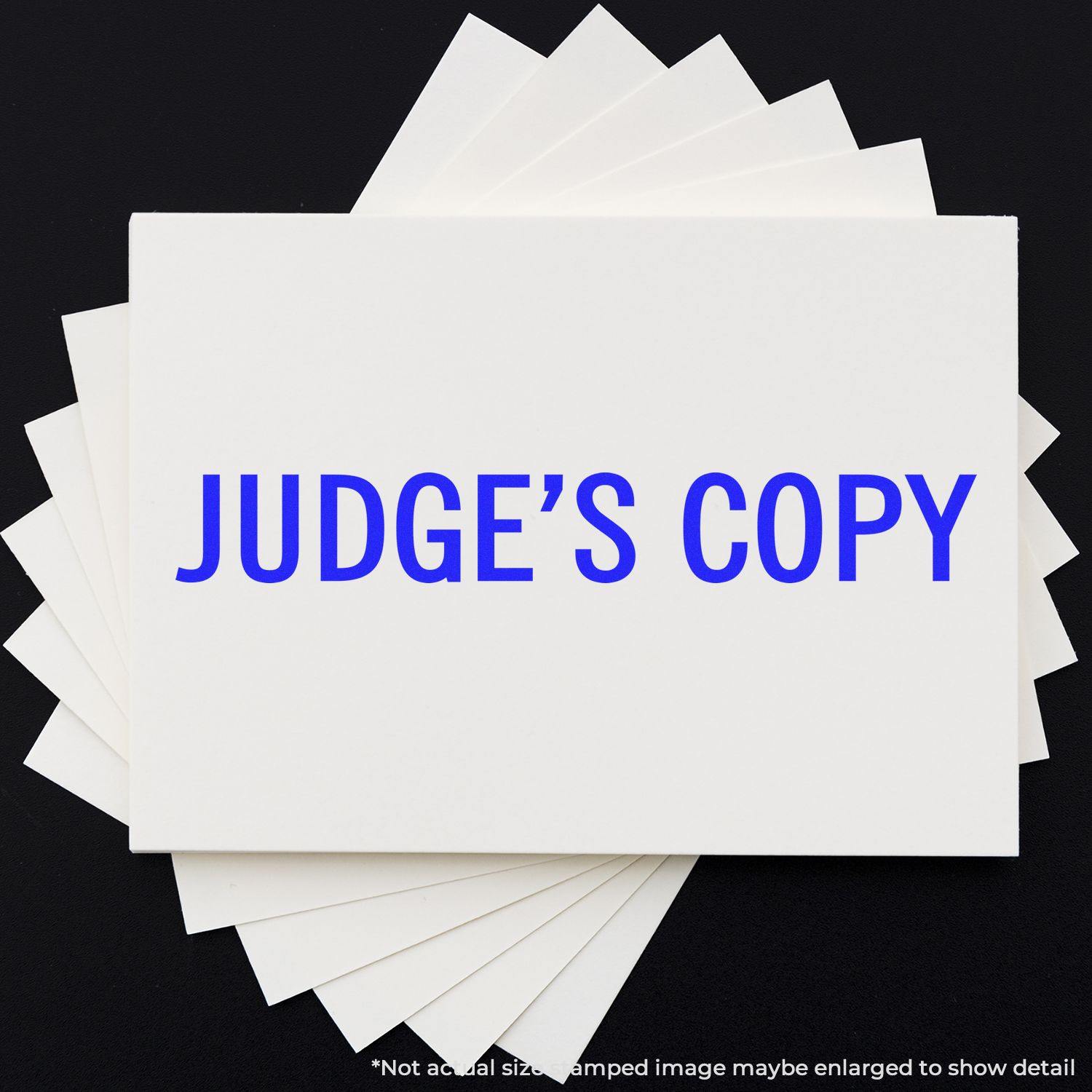 Judge's Copy Rubber Stamp in blue ink on a white card, surrounded by several other white cards on a black background.