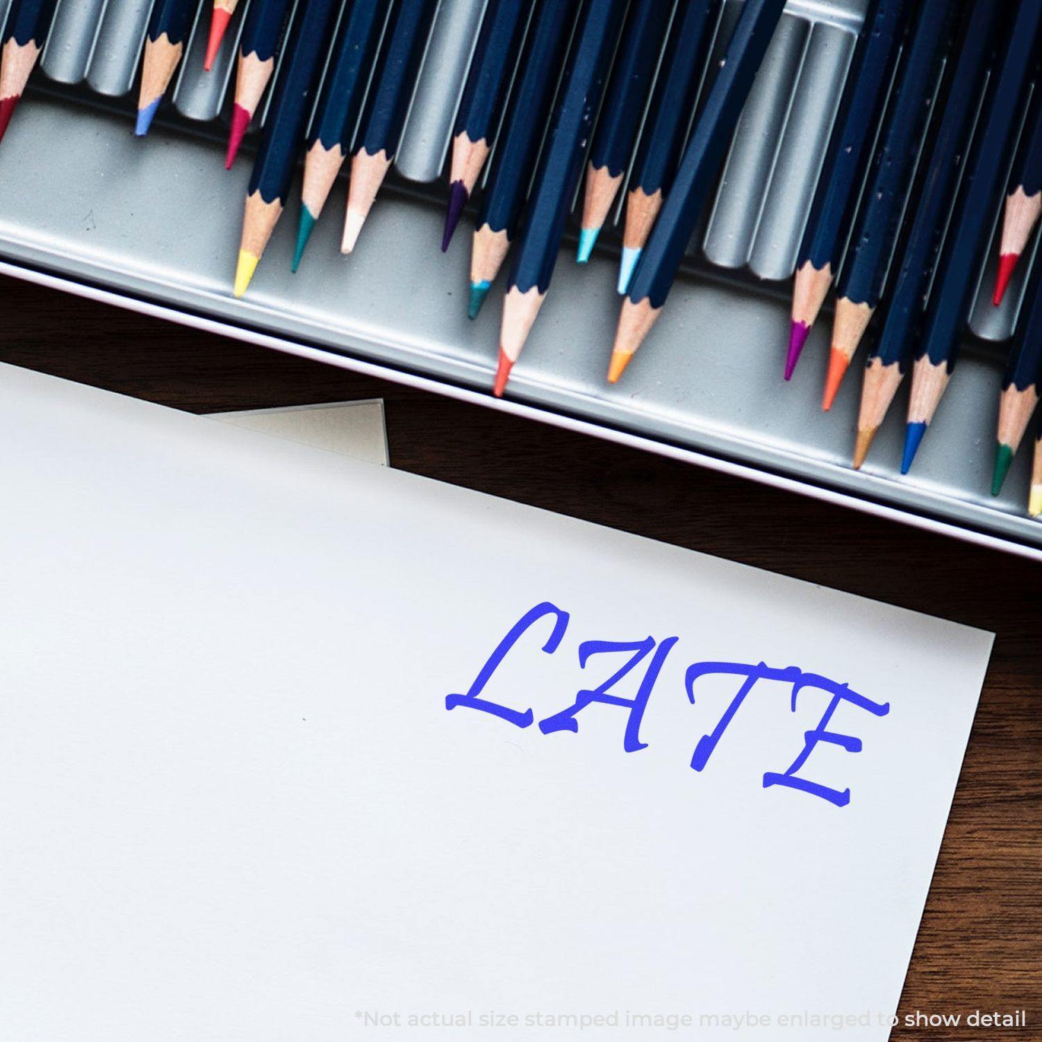 A paper stamped with LATE in blue ink using the Large Late Rubber Stamp, with colored pencils in the background.