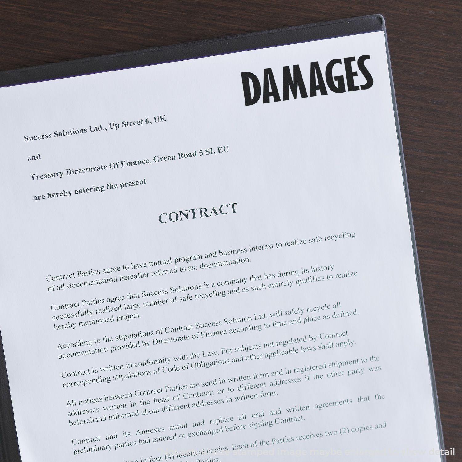 A Large Damages Rubber Stamp is used on a contract document, highlighting the word DAMAGES in bold black letters at the top right corner.