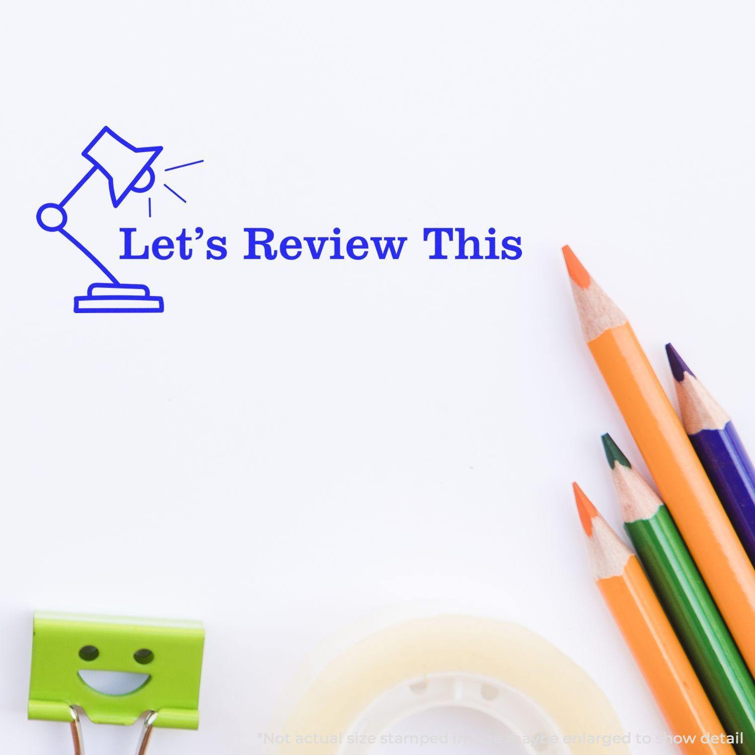 Let's Review This with Lamp Rubber Stamp in blue ink on white paper, surrounded by colored pencils, tape, and a smiling paper clip.